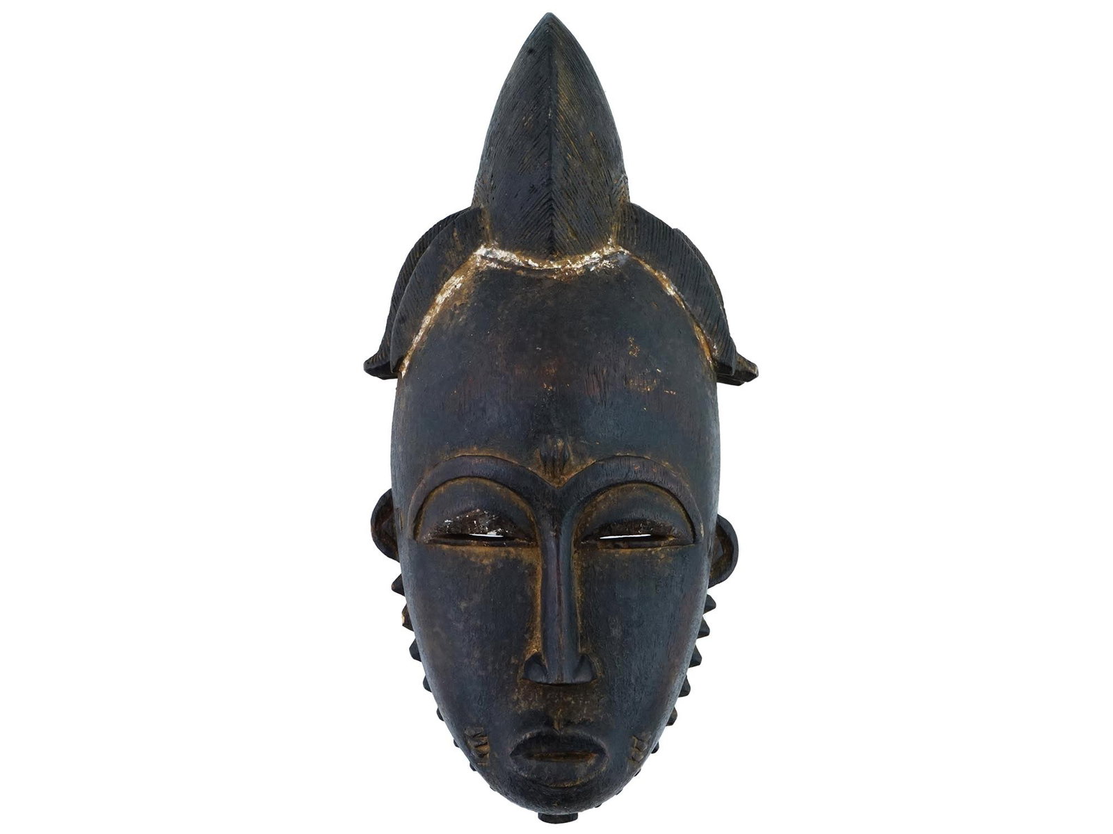 ANTIQUE AFRICAN BAULE TUNTUM HAND CARVED WOOD MASK: An antique Central African Baule Tuntum hand craved mask. The mask is modeled with narrow eyes, a small mouth, and a headdress. Tuntum in the Akan language means black. This type of African mask is a 