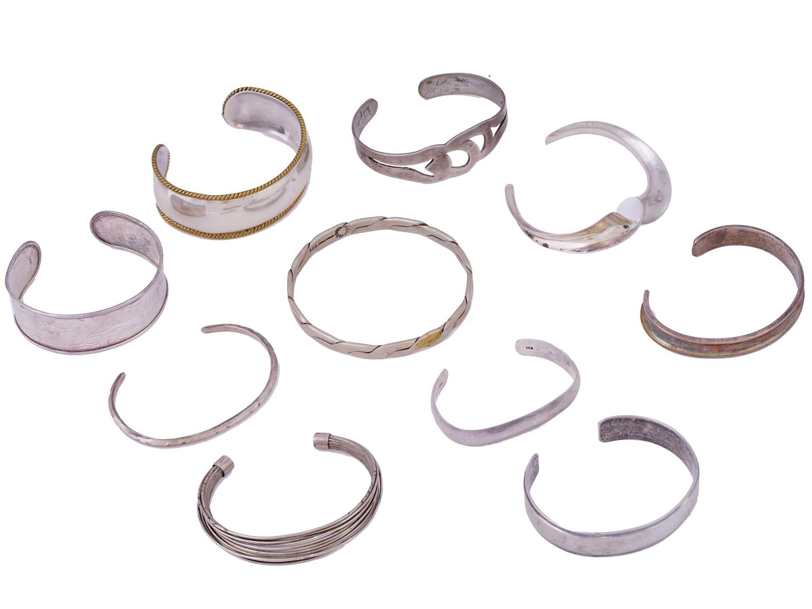 MEXICAN AND GERHARDT STERLING SILVER CUFF BRACELETS: A lot of vintage bracelets made of silver-tone metal and sterling silver. Cuff type, various designs. A total of 11 items. Includes a piece by Gerhardt Sterling, a popular mid century brand of Moderni