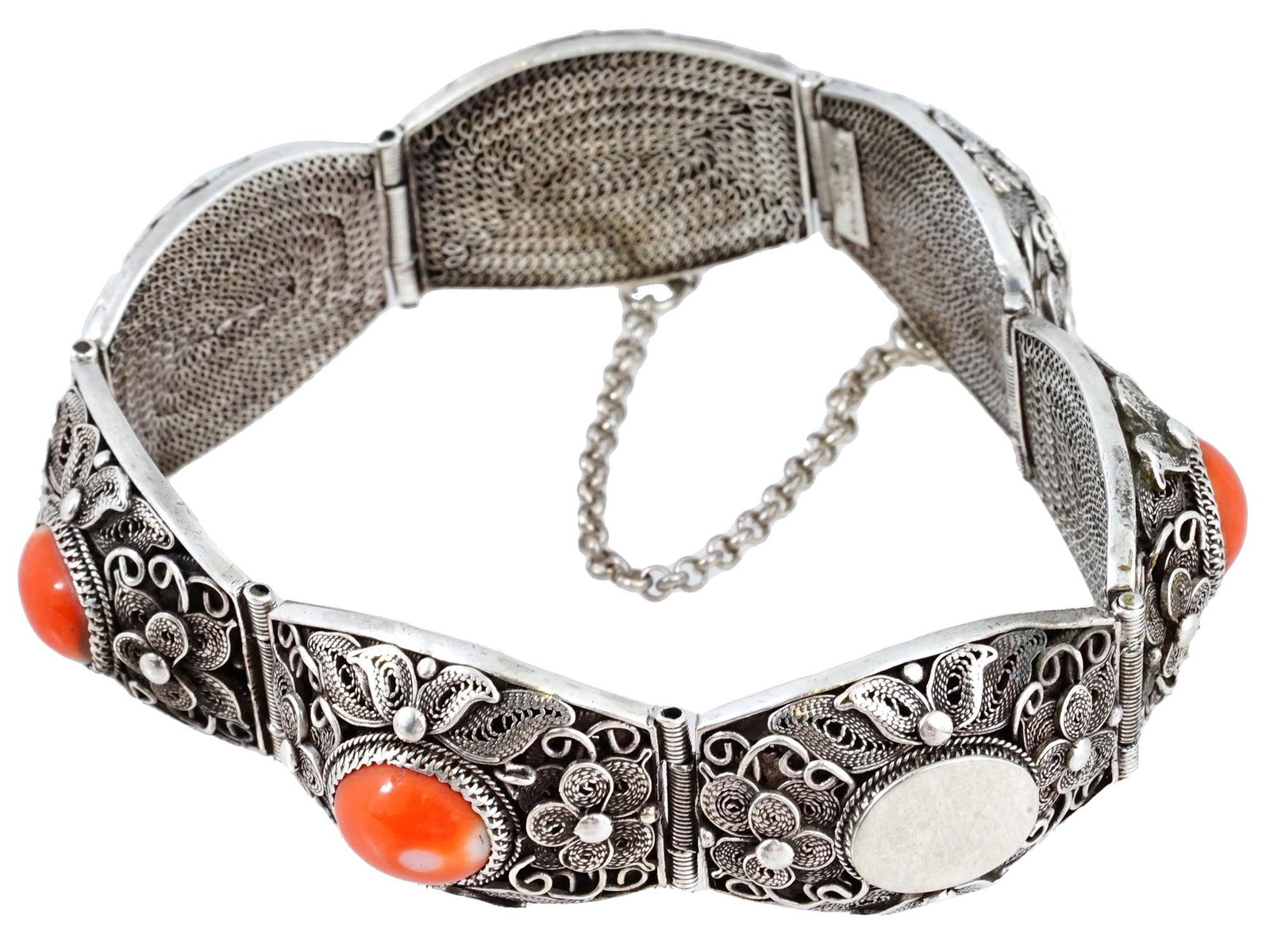 VINTAGE SILVER FILIGREE BRACELET SET WITH CORALS: A vintage silver filigree bracelet set with large red corals of oval shape. Granulated and swirl decor with floral motifs. The link chain is attached to the clasp. Southwestern Navajo Style Silverware
