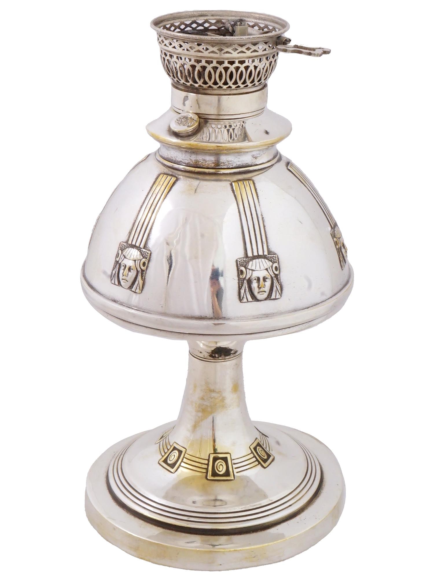 ANTIQUE VICTORIAN MANNER METAL KEROSENE LAMP: An antique Victorian manner metal kerosene lamp. The exterior of the lamp is adorned with engraved images of faces. A foot is adorned with an engraved swirl ornament. Unmarked. Circa: late 19th centur