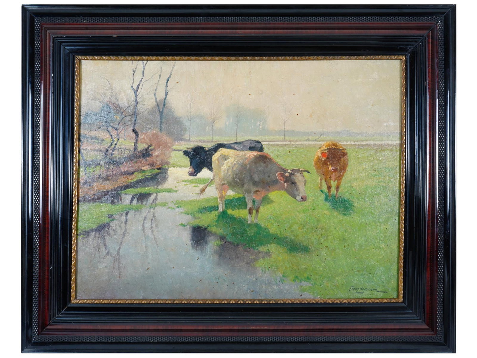 GERMAN COWS GRAZING PAINTING BY FRANZ HOCHMANN: Franz Gustav Hochmann, German, 1861 to 1935, an oil painting on canvas depicting cows grazing by water in a landscape. Signed lower right. Framed. Franz Hochmann studied at the academy in Dresden, as 