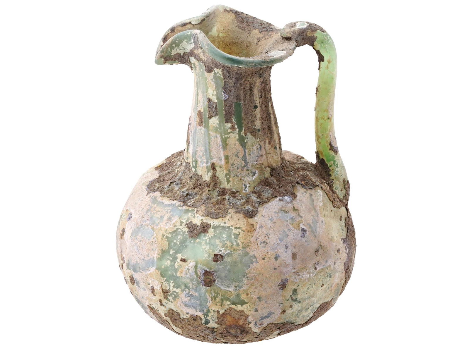 ANCIENT ROMAN GLASS OINOCHOE JUG: An ancient Roman glass oinochoe jug or pitcher. The jug, made of light green glass, has an ovoid body with a tall cylindrical and ribbed neck and trefoil lip. An undulating trail around the base of th