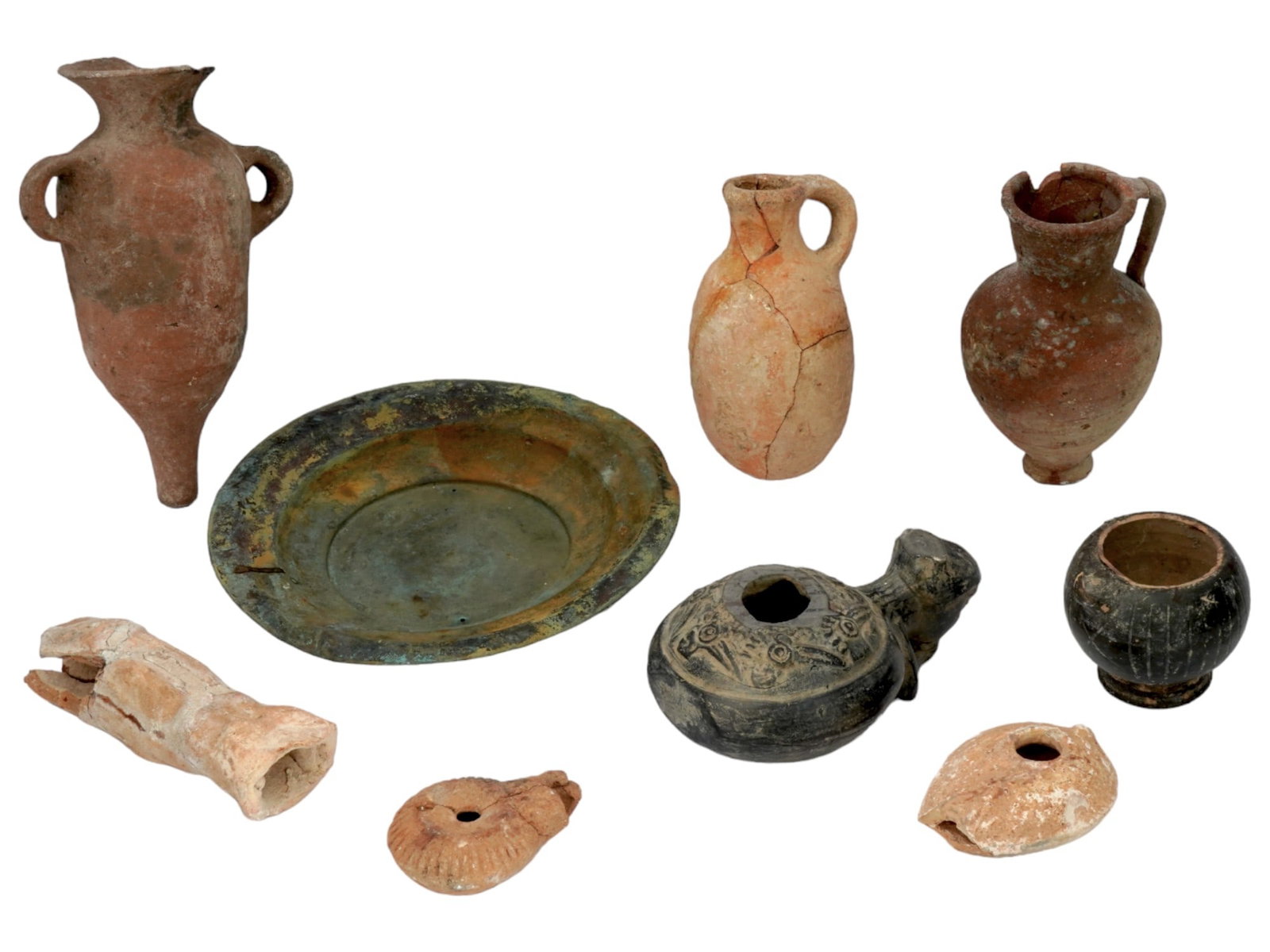 ANCIENT ROMAN TERRACOTTA BRONZE AMPHORA POT LAMPS JUGS: A lot of ancient Roman terracotta items and a bronze plate. Circa: 30 BC to 400 AD. The lot includes: one amphora for oil or wine, two jugs with handles, two brown oil lamps and one painted black with