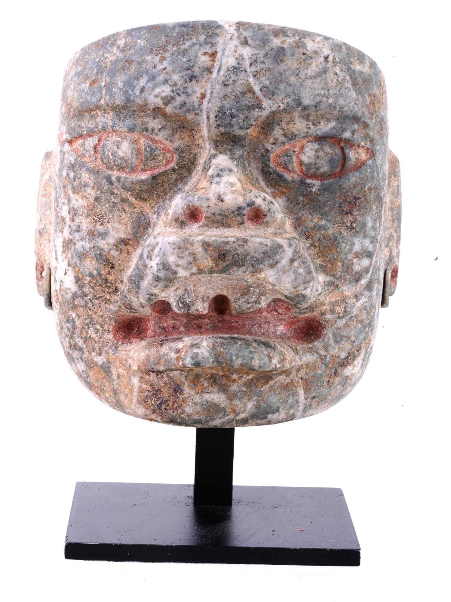 ANCIENT PRE COLUMBIAN AMERICA OLMEC MASK: An ancient Olmec mask from Pre Columbian America made of red stone. This is a scary mans face with a flat head, big carved eyes, and a mouth resembling the mouth of a jaguar. There are through holes i