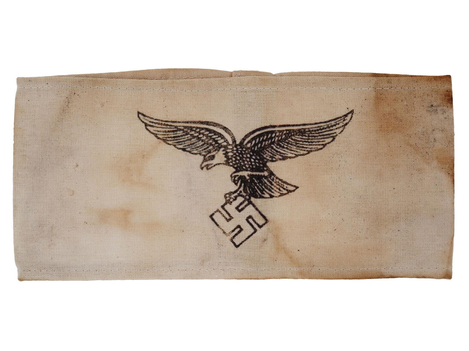 WWII NAZI GERMAN LUFTWAFFE EAGLE WITH SWASTIKA ARMBAND: A World War II Nazi German Luftwaffe armband featuring a black printed Luftwaffe eagle in flight clutching a swastika on white fabric. Second World War Nazi German Third Reich Military Collectibles. D