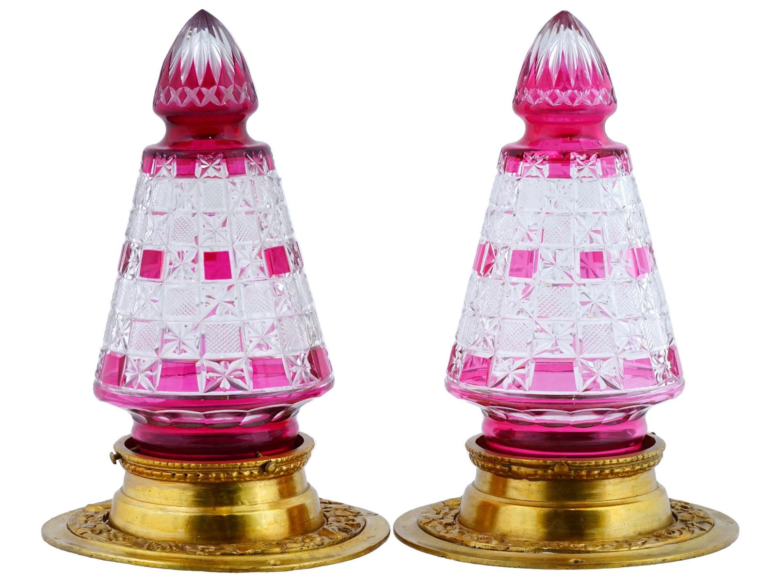 PAIR OF VINTAGE BRONZE AND CUT GLASS WALL LIGHTS: A pair of vintage bronze and cut glass wall lights. Conical shaped lamps with a geometric pattern with pink accents. The gilded bronze base of the lamps is decorated with relief wreaths of flowers and