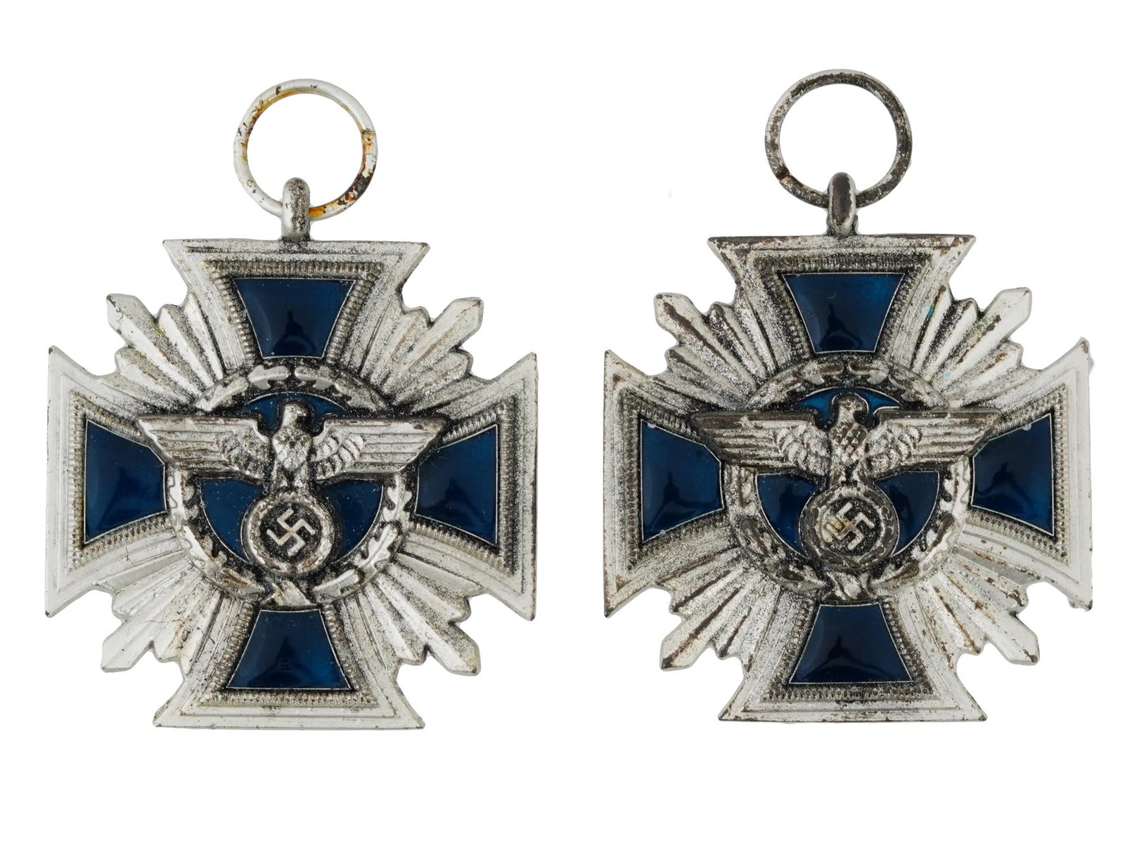 GERMAN WWII NSDAP LONG SERVICE AWARD MEDALS: A lot of two WWII German NSDAP Long Service award medals featuring the cross shape with a silver tone outline and dark blue enamel filling the four arms of the cross. Behind the cross, silver rays ext