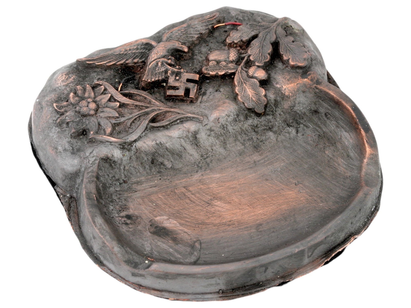 GERMAN WWII TYPE LUFTWAFFE PILOTS ASHTRAY: A WWII type Nazi German Third Reich Luftwaffe pilots patinated metal ashtray. The ashtray features relief images of an Edelweiss flower, an eagle clutching a swastika insignia, and an oak branch with 