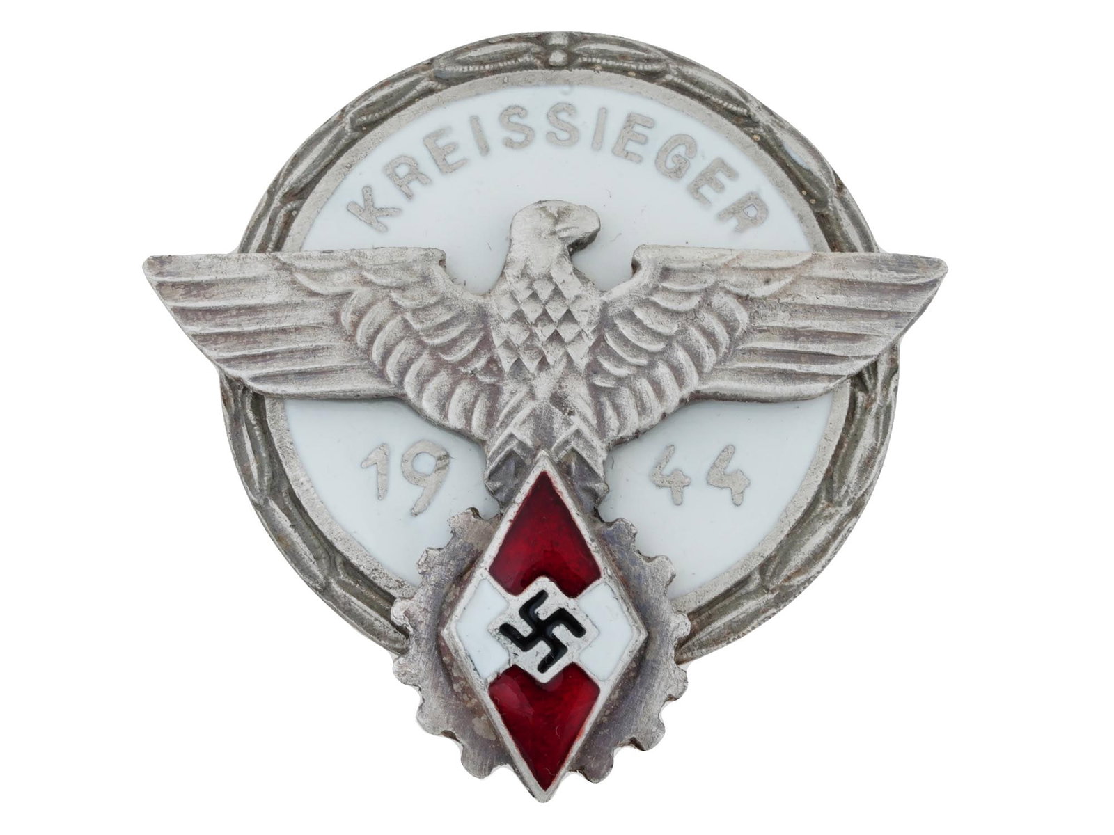 GERMAN WWII TYPE MILITARY HITLER YOUTH KREISSIEGER PIN: A WWII type German Nazi Third Reich Military Hitler Youth metal pin shield. The obverse surrounded by a laurel wreath depicts an enameled white surface and text that reads Kreissieger 1944. A German n