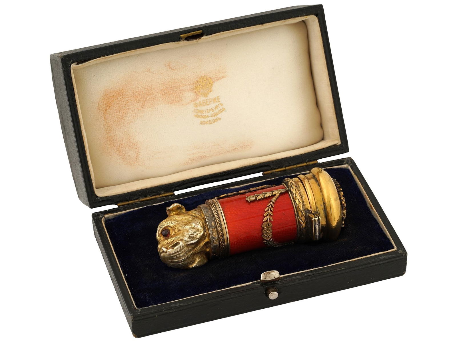 RUSSIAN GILT SILVER ENAMEL GEMSTONE DOG PILL BOX: A Russian gilt silver pill box with hinged lid. Bulldog head design. The eyes of the dog are set with ruby cabochons. Red guilloche enamel body, ornamental overlay and Imperial eagle coat of arms set