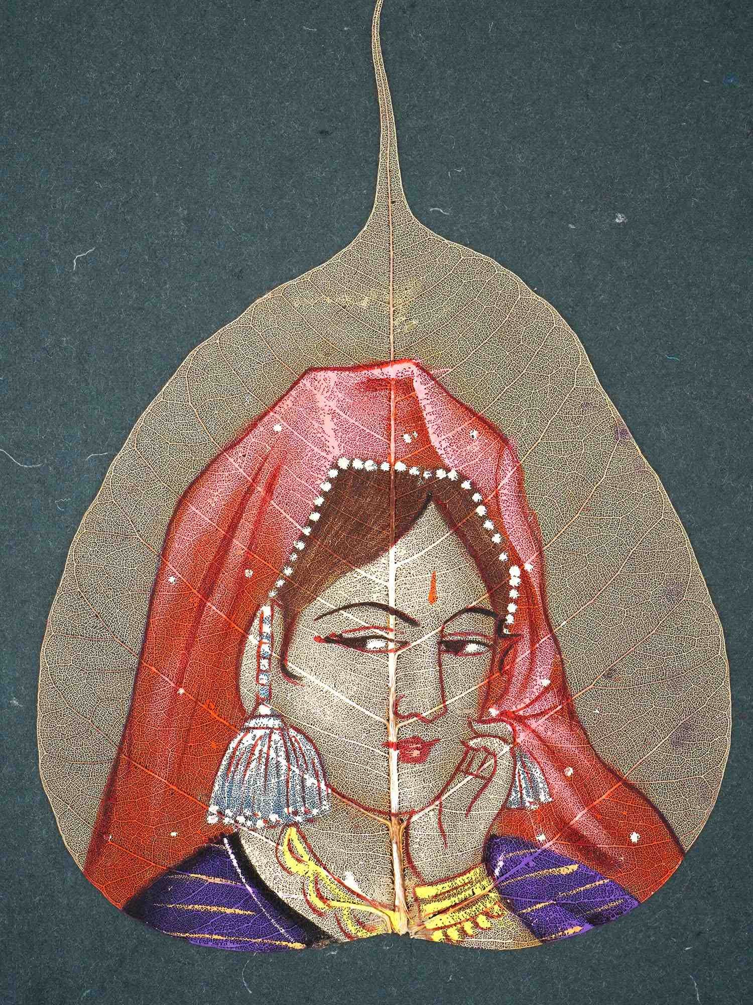 INDIAN HAND PAINTING ON BANYAN LEAF: An Indian hand painting on a leaf. The artwork features a beautiful portrait of an Indian woman in a vibrant red and purple outfit, highlighted by delicate details such as intricate jewelry and expres