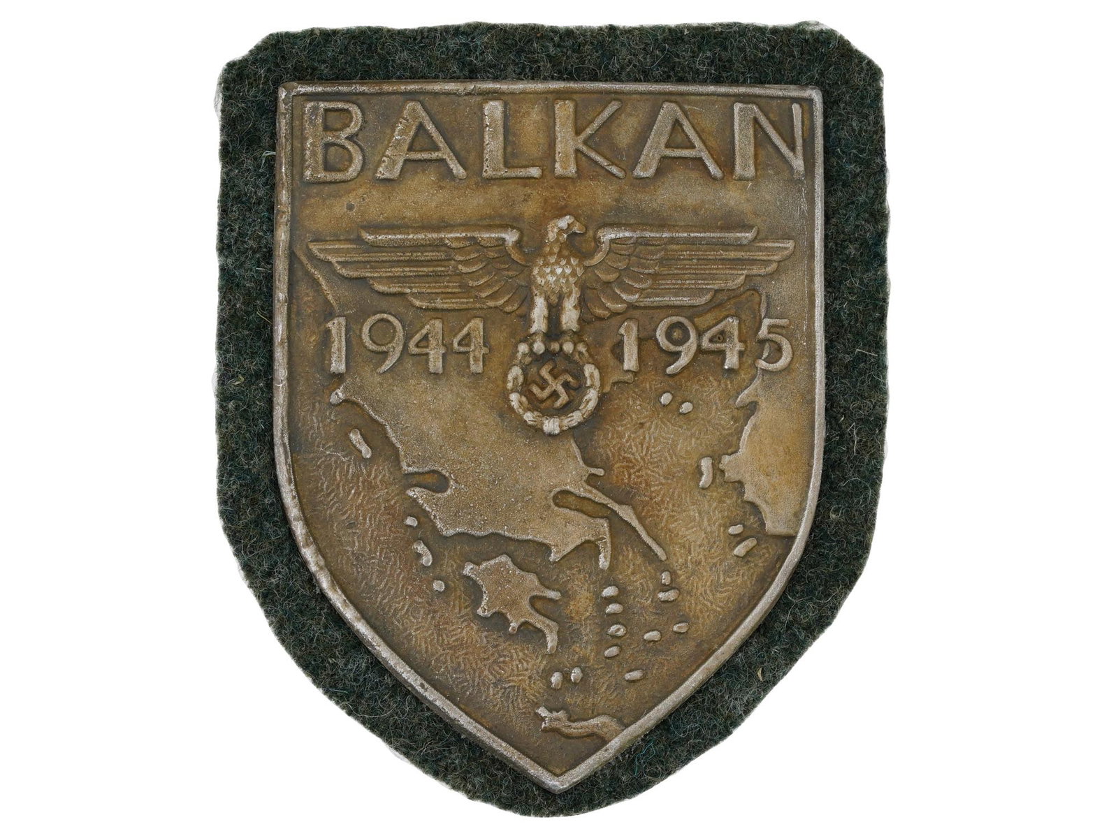 RARE WWII TYPE NAZI GERMAN BALKAN SHIELD BADGE: A rare WWII type German Balkan shield badge. It was designed by Benno von Arent and had the text Balkan with the dates 1944 and 1945 on either side of an eagle with swastika over a map of the Balkans.