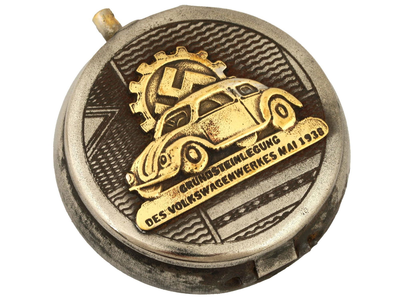 WWII GERMAN VOLKSWAGEN LOGO POCKET ASHTRAY: A World War II type Nazi German stainless steel military pocket ashtray with hinged lid. The lid is decorated with a gilt overlay Volkswagen logo. There is a cigarette groove holder inside. Marked RZM