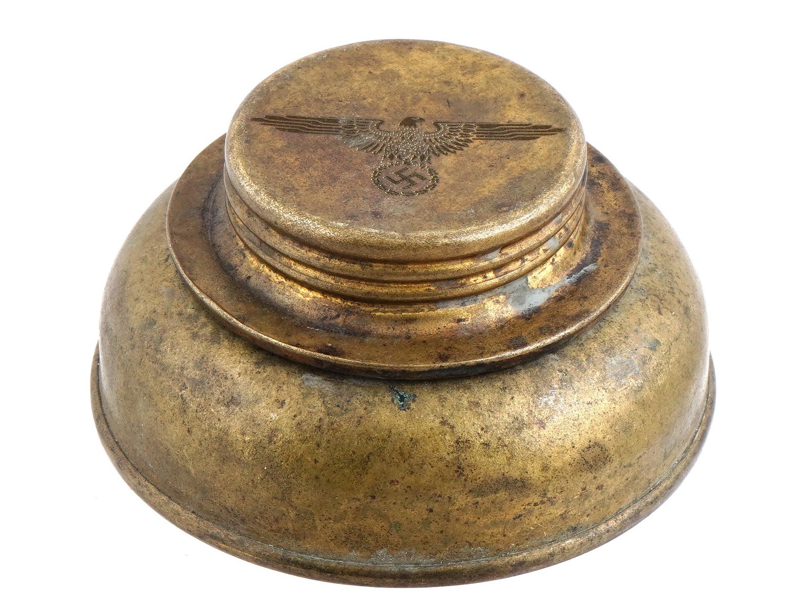 WWII NAZI GERMAN WAFFEN SS TRENCH CANDLE STICK BASE: A WWII type Nazi German Waffen SS trench candle stick base. The item is raised on a round base and features a relief image of the Nazi German coat of arms in the form of an eagle holding a swastika in