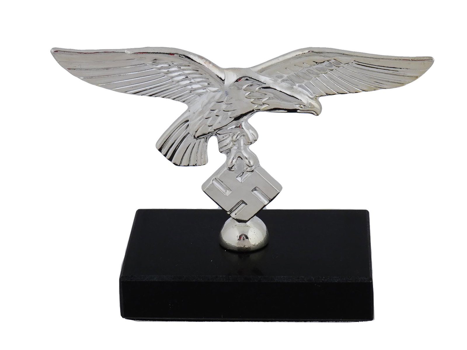 GERMAN WWII LUFTWAFFE EAGLE TABLE FIGURINE: A World War II Nazi German type patriotic desk decor, a steel figurine representing the Reichsadler, a German eagle with a swastika, the symbol of the Luftwaffe. The piece is mounted on a black stone 