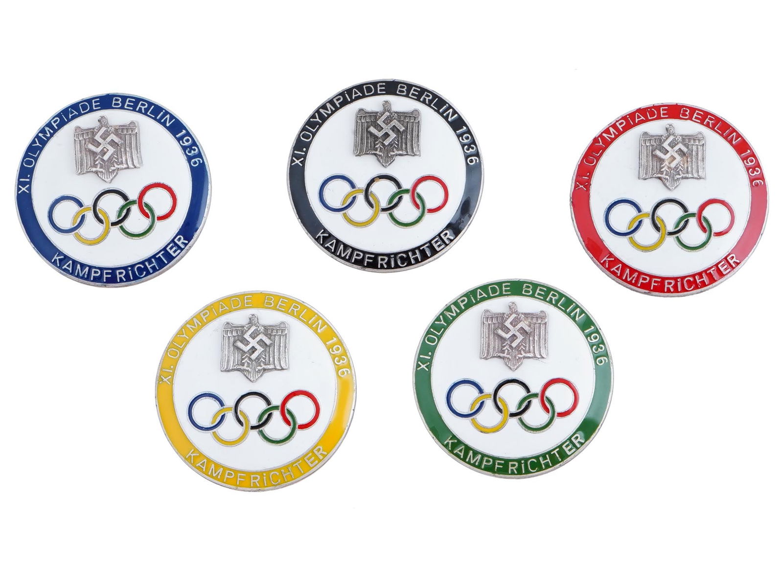 GERMAN PRE WWII TYPE OLYMPICS REFEREE ENAMEL PIN BADGES: A group of five German pre WWII type 1936 Berlin Olympics referee multicolored enamel pin badges, each featuring a Nazi eagle with a swastika above the Olympic rings. Marked with an impressed mark, on