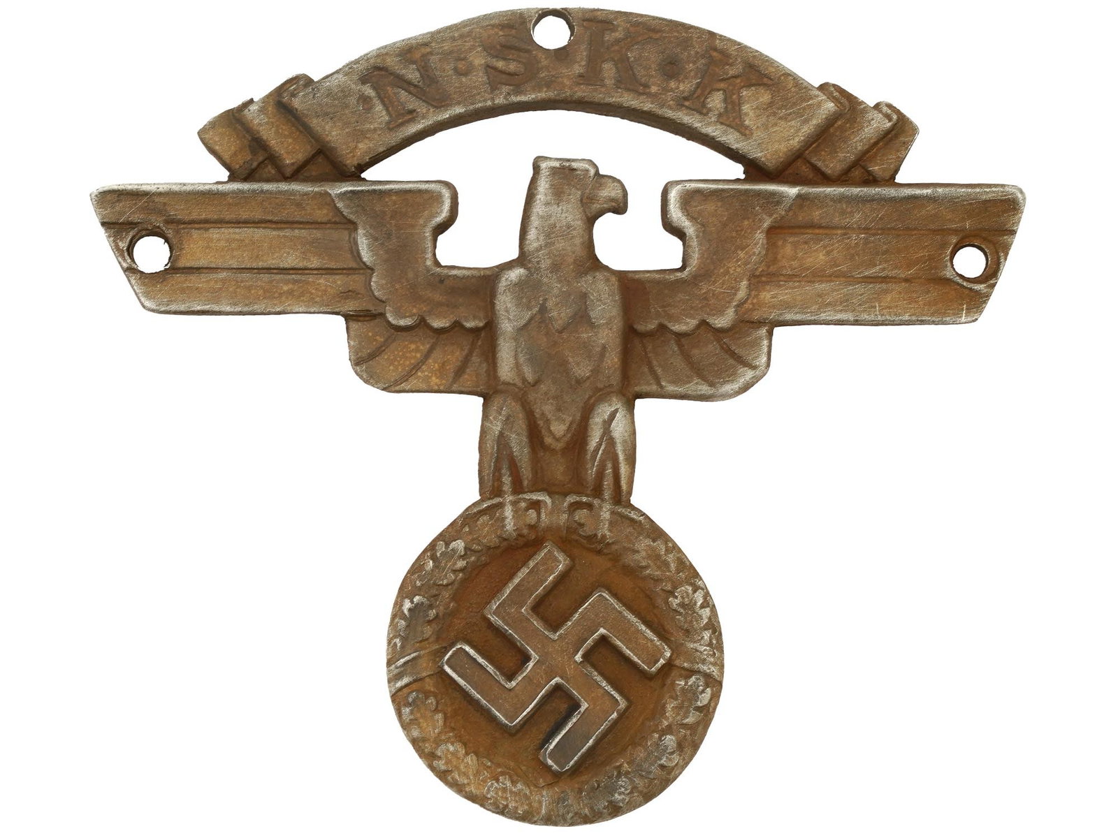 WWII NAZI GERMAN NSKK MOTORCYCLE HELMET BADGE: A WWII type Nazi German NSKK motorcycle helmet badge. Featuring an eagle clutching an oak leaf wreath with a swastika and NSKK inscription above. Hallmarked on the back. Bears a pin and a catch fixing