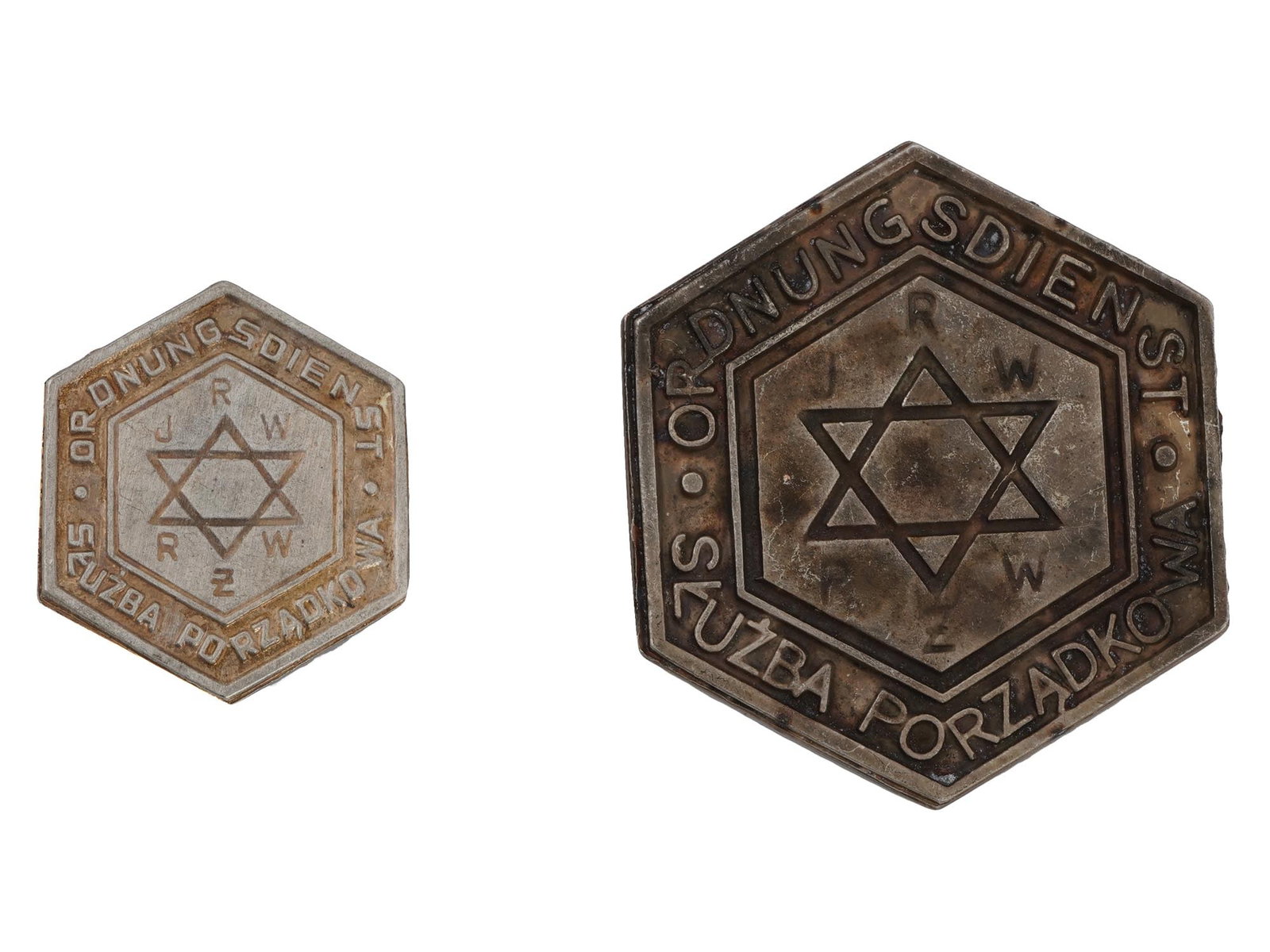 WWII MODEL WARSAW JEWISH GHETTO POLICE BADGES: A pair of World War II type Polish metal badges of Warsaw ghetto police. Breast and hat badges, various size. Hexagonal pieces with Magen David, inscription Ordnungsdienst Sluzba Porzadkowe, JRW RZW. 