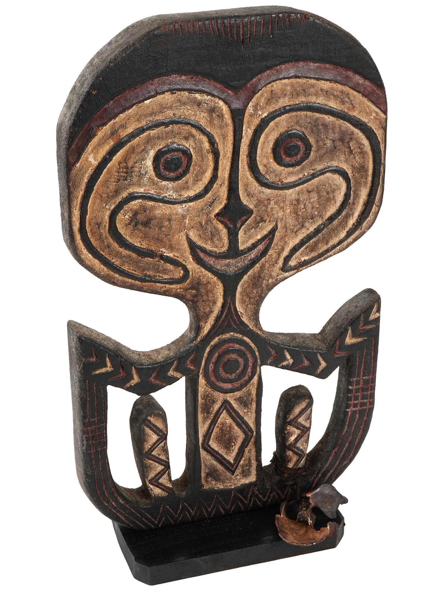 NEW GUINEAN CARVED WOODEN AGIBA SKULL FIGURE: A Papua New Guinean hand carved wooden skull hook, hanger, or Agiba figure, of Kerewa people. The figure features a flat shape with traditional hand carved patterns, covered with white pigment and mou