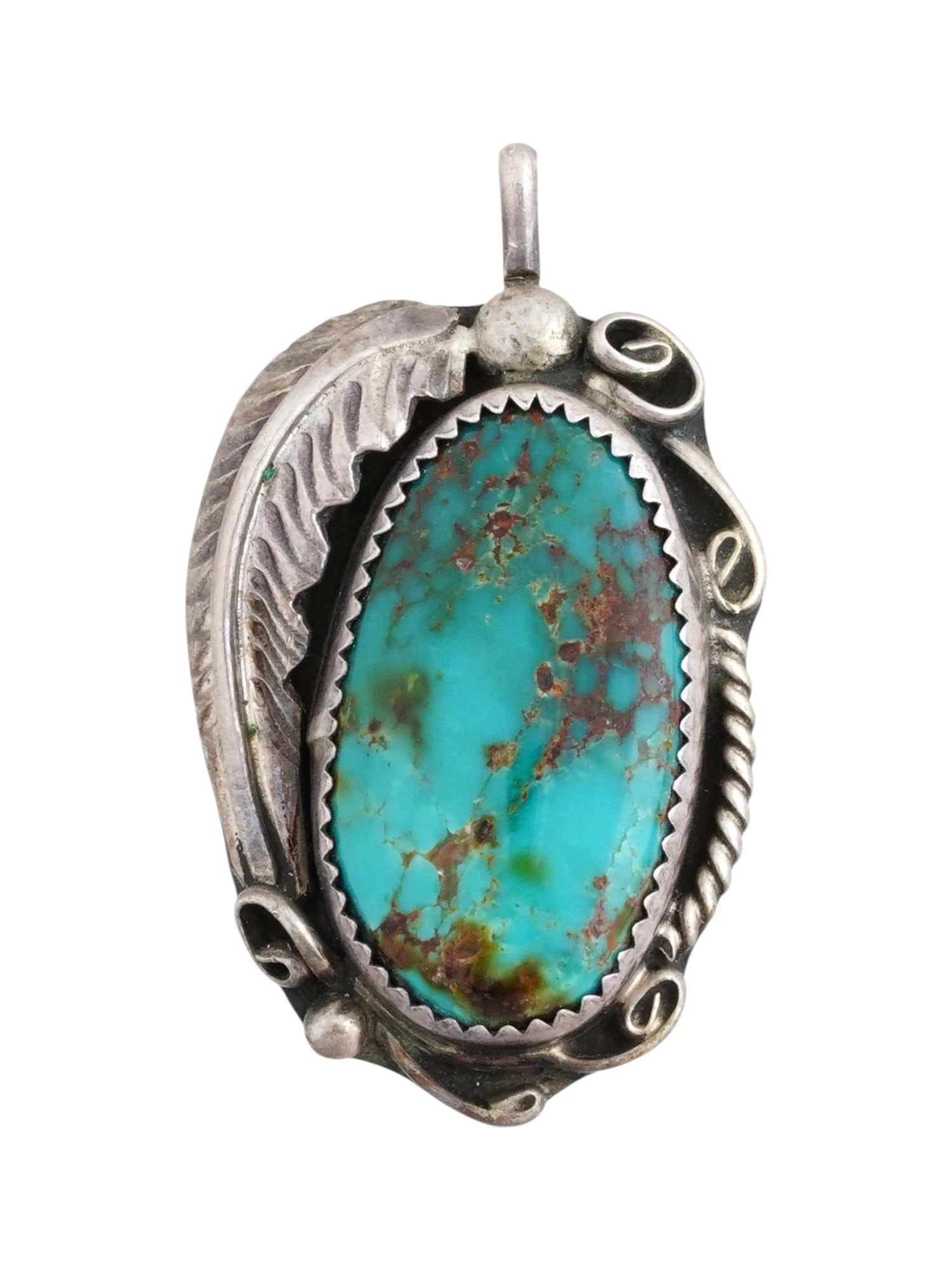 OLD PAWN NATIVE AMERICAN SILVER TURQUOISE PENDANT: An Old Pawn Native American sterling silver pendant featuring a polished turquoise stone in a frame within a foliage design. With a suspension loop. Hallmarked. Tribal Necklaces And Gemstone Jewelry C