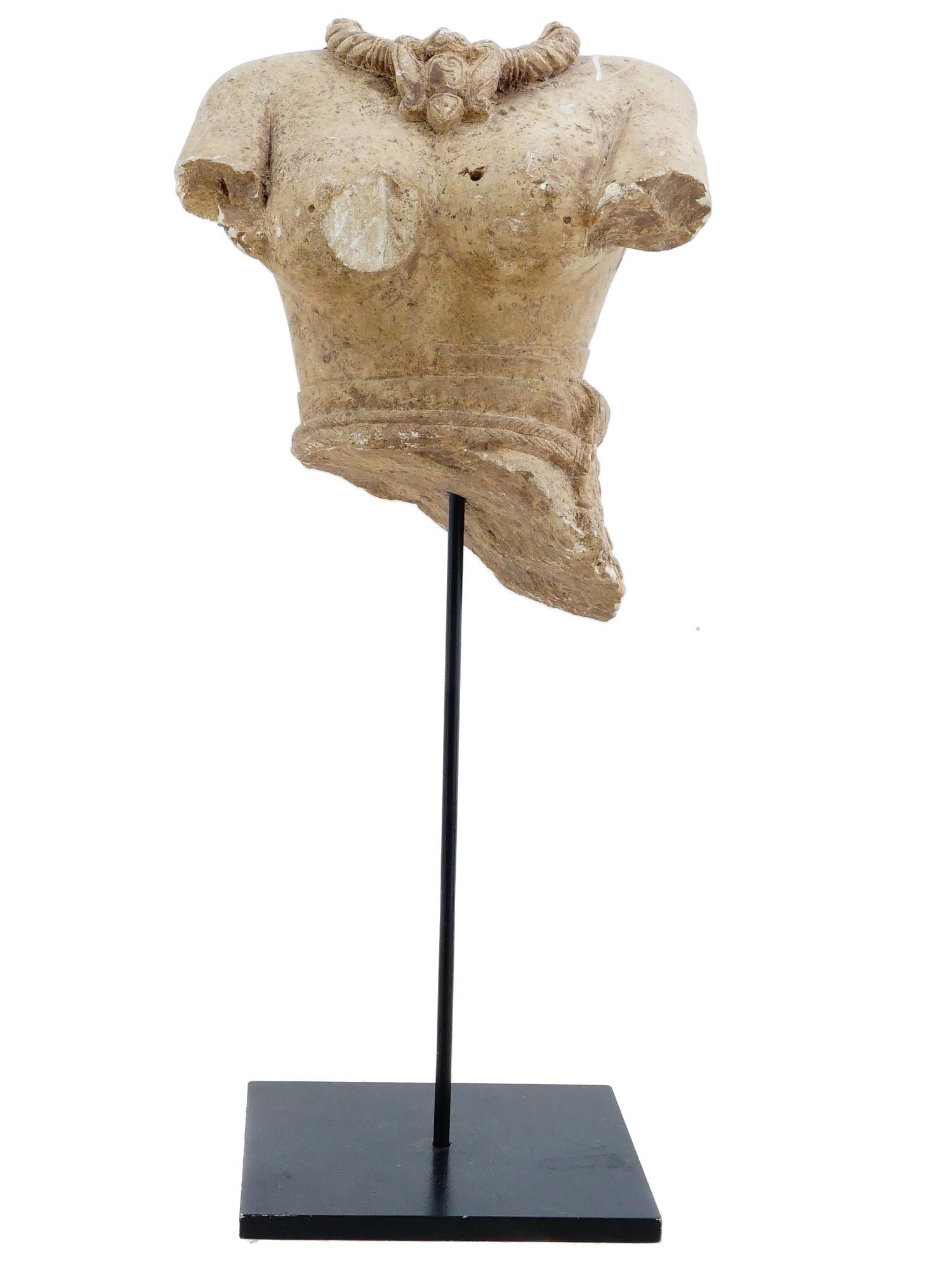 ANCIENT GANDHARA LIMESTONE FEMALE BUST FRAGMENT 400 AD: An ancient Pakistan Gandhara limestone female bust fragment. Dates to the 400 AD. The fragment of a female body, possibly a dancer, presented with elements of clothing and jewelry. Comes with a stand.