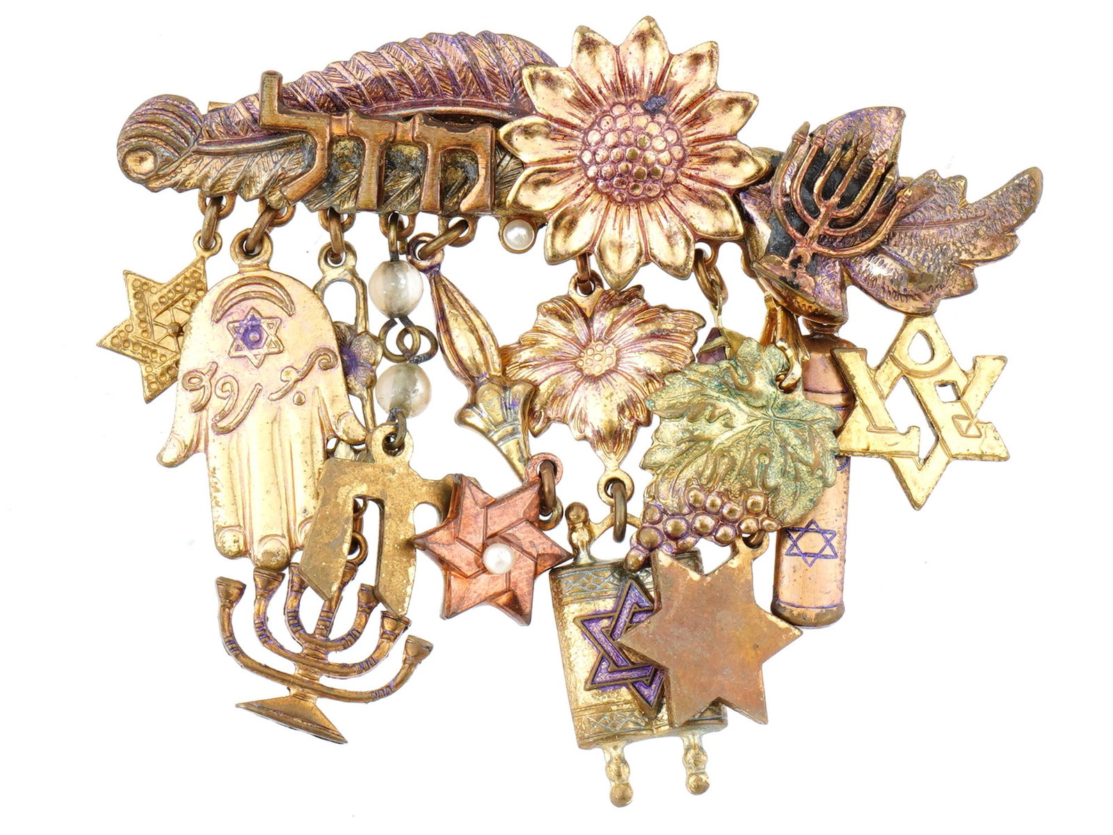 MODERN JUDAICA JEWELRY BROOCH WITH VARIOUS CHARMS: A Modern Judaica jewelry brooch. The brooch is adorned with various charms. The charms are made in the Star of David, floral, Hamsa hand, Menorah, and other design. Each charm is engraved with detaile