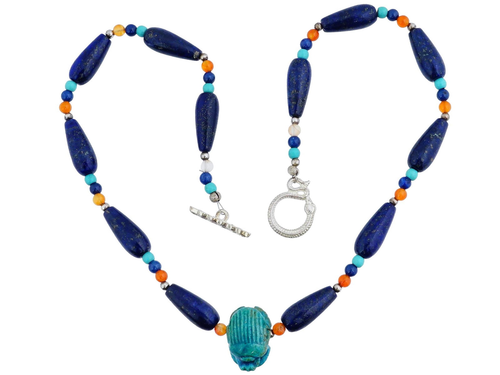 ANCIENT EGYPTIAN NECKLACE WITH SCARRAB 3RD BC TO 3RD AD: An ancient Egyptian necklace composed of an eclectic mix of stones, including lapis lazuli, carnelian and scarab bead. The piece is finished with a toggle clasp with a snake motif. Circa: 3rd BC to 3r