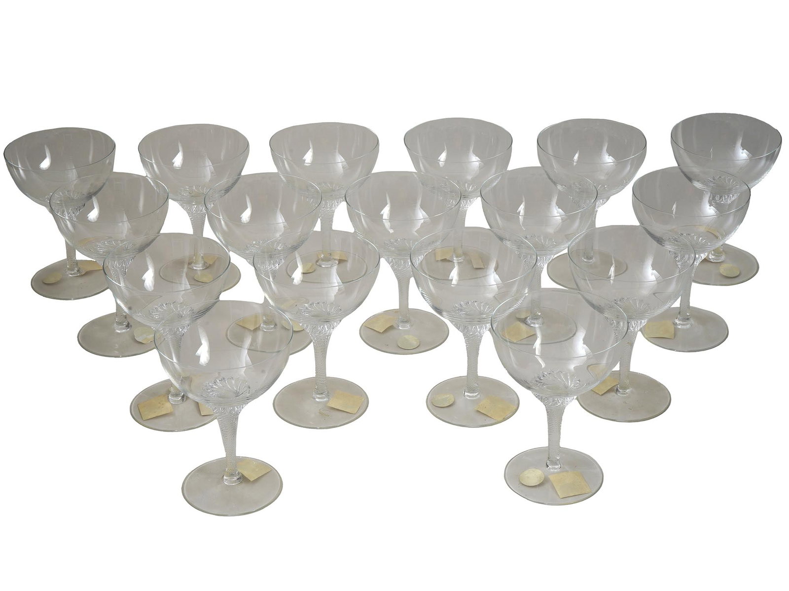 VINTAGE CRYSTAL WINE GLASSES SET: A lot of vintage clear lead glass wine goblets. A total of 17 glasses for white wine or champagne. Swirl stem design. Unmarked. Provenance: Christies, Sale 1543, 2005. Each piece has an auction label 