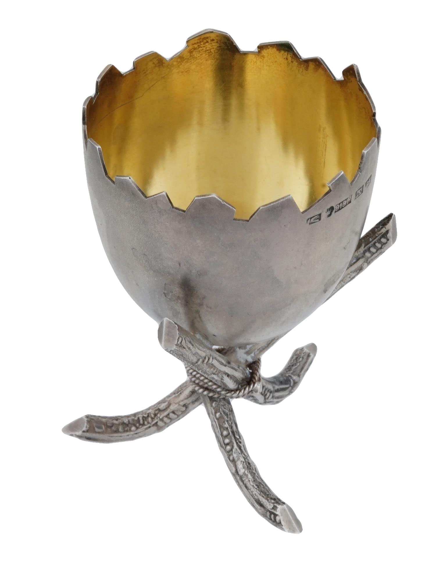 ANTIQUE FINNISH GILT STERLING SILVER EGG STAND: An early 20th-century Finnish gilt silver footed egg stand. Broken egg shell design. Gilt interior. Figurative tripod foot. Makers mark TA, crown mark, 813H silver standard, P5 for the year 1920 are o