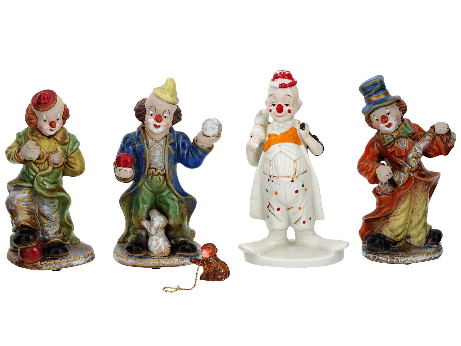 FOUR VINTAGE PORCELAIN CLOWN FIGURINES C 1980: The set includes a vintage Nanco hand painted porcelain clown figurine, and three Hobo clown figurines: a juggling clown, a clown with glasses and a clown wearing a cylinder painted in cobalt blue and
