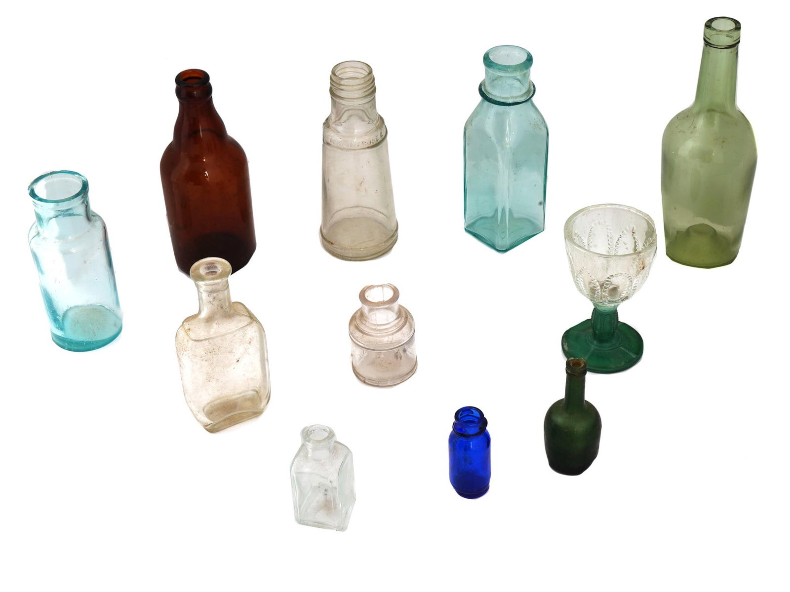 VINTAGE GROUP OF MINIATURE BOTTLES AND WINE GLASS: A vintage collection of miniature bottles of various designs and a wine glass. In total 10 bottles and 1 wine glass. Bottles of different sizes, shapes and colors. The Cordial stemmed wine glass was c