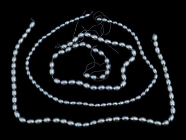 THREE VINTAGE STRINGS OF OVAL NATURAL PEARL BEADS