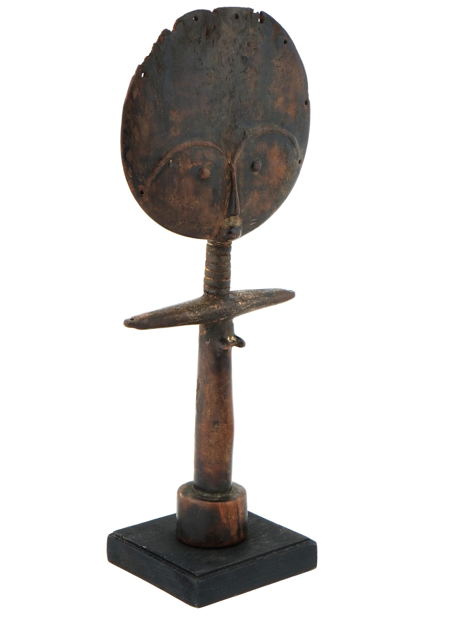WEST AFRICAN ASHANTI GHANA WOODEN FIGURINE DOLL: A traditional hand carved wooden doll figurine on stand from the Ashanti tribe, Ghana, West Africa. The figurine features a round face with stylized eyes and a nose. The face is attached to a slender,