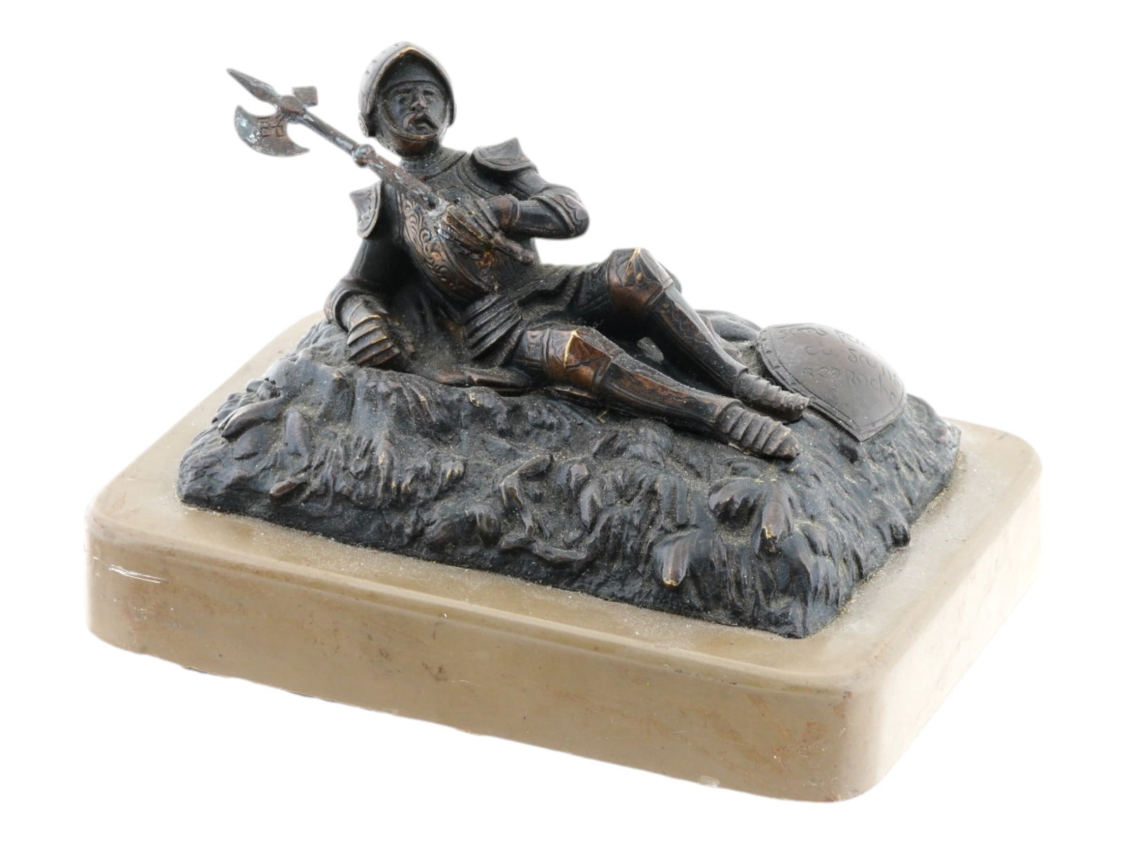 ANTIQUE FRENCH GRAND TOUR BRONZE KNIGHT FIGURE: An antique early 20th-century French bronze knight figure depicted reclining in full armor with a weapon in his left hand, while a shield with the inscription Without Fear or Blame in French rests bes