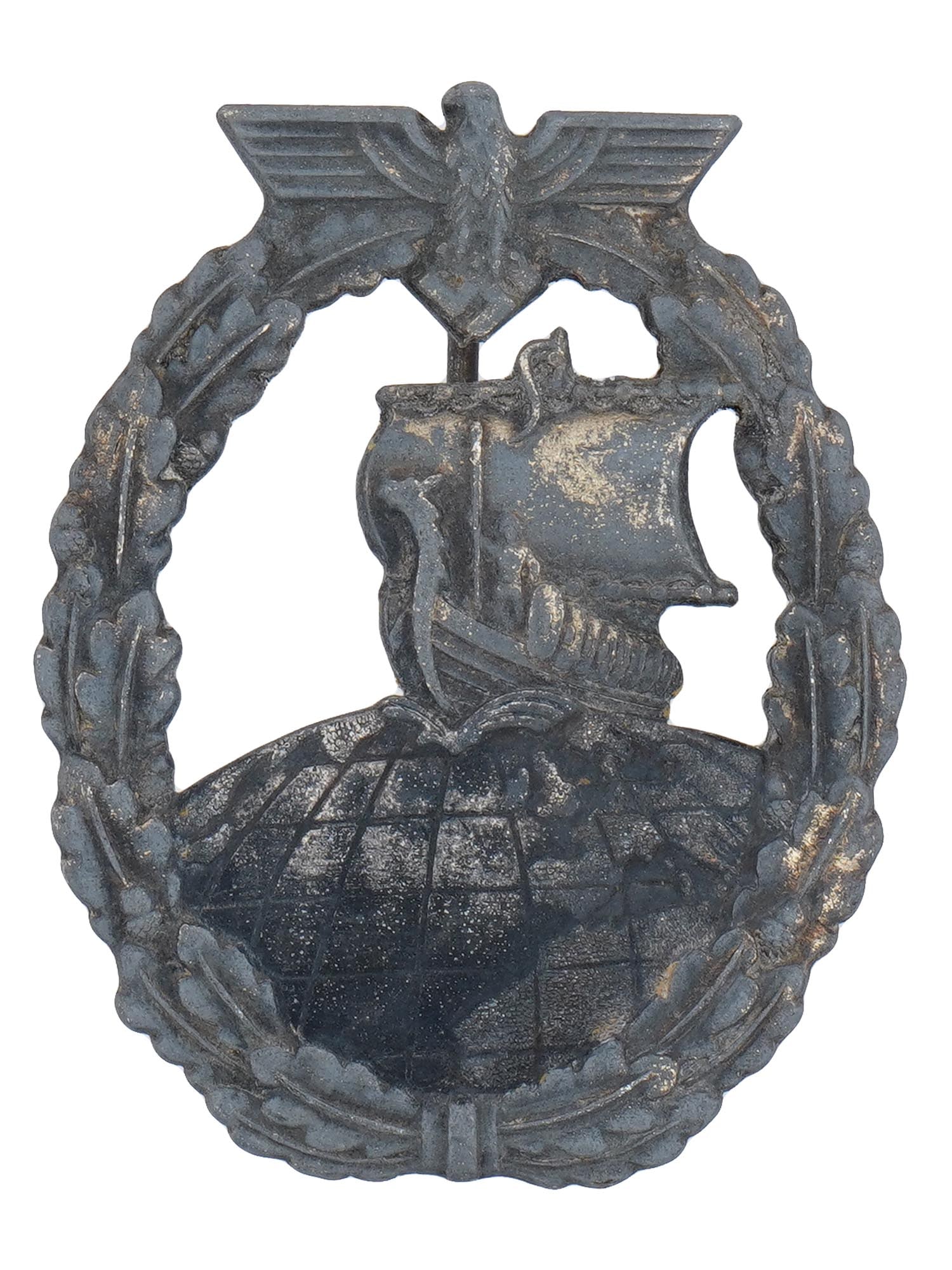WWII GERMAN KRIEGSMARINE AUXILIARY CRUISER BADGE: A WWII Nazi German Kriegsmarine Auxiliary Cruiser Badge. An oval shaped badge shows a Viking ship sailing on the top of the globe, within an oak leaf wreath with the Nazi eagle and swastika. The Auxil