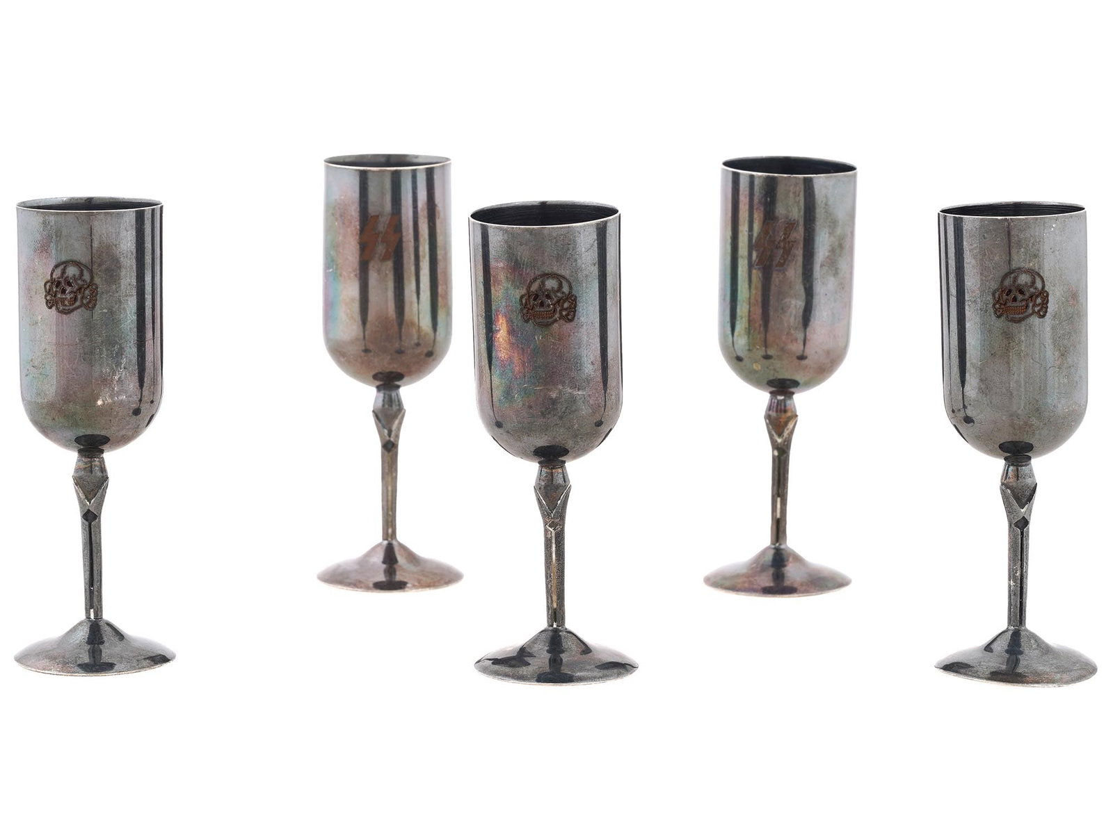 FIVE WWII TYPE NAZI GERMAN TOTENKOPF GOBLETS: A set of five WWII type Nazi German goblets. The goblets are elongated and raised on thin, high stems. The pieces are decorated with applied Totenkopf skull emblems and SS runes. Second World War Hist