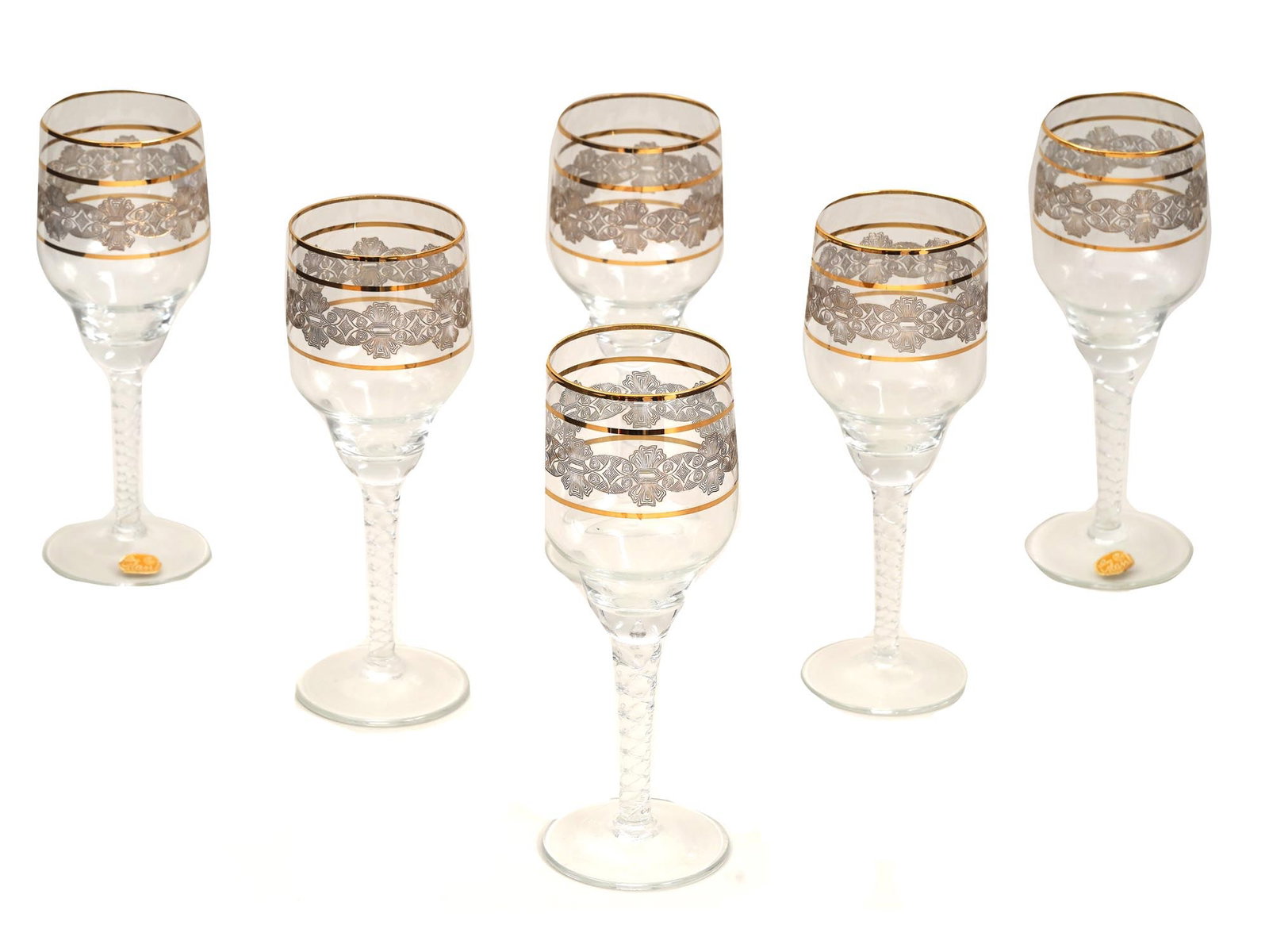 VINTAGE SET OF SIX CZECH BOHEMIAN WINE GLASSES: A vintage set of six Czech Bohemian wine glasses. Circa 1950s to 1970s. The glasses feature an intricate geometric pattern with gold accents. Raised on a stem with a woven relief pattern. Labeled Bohe
