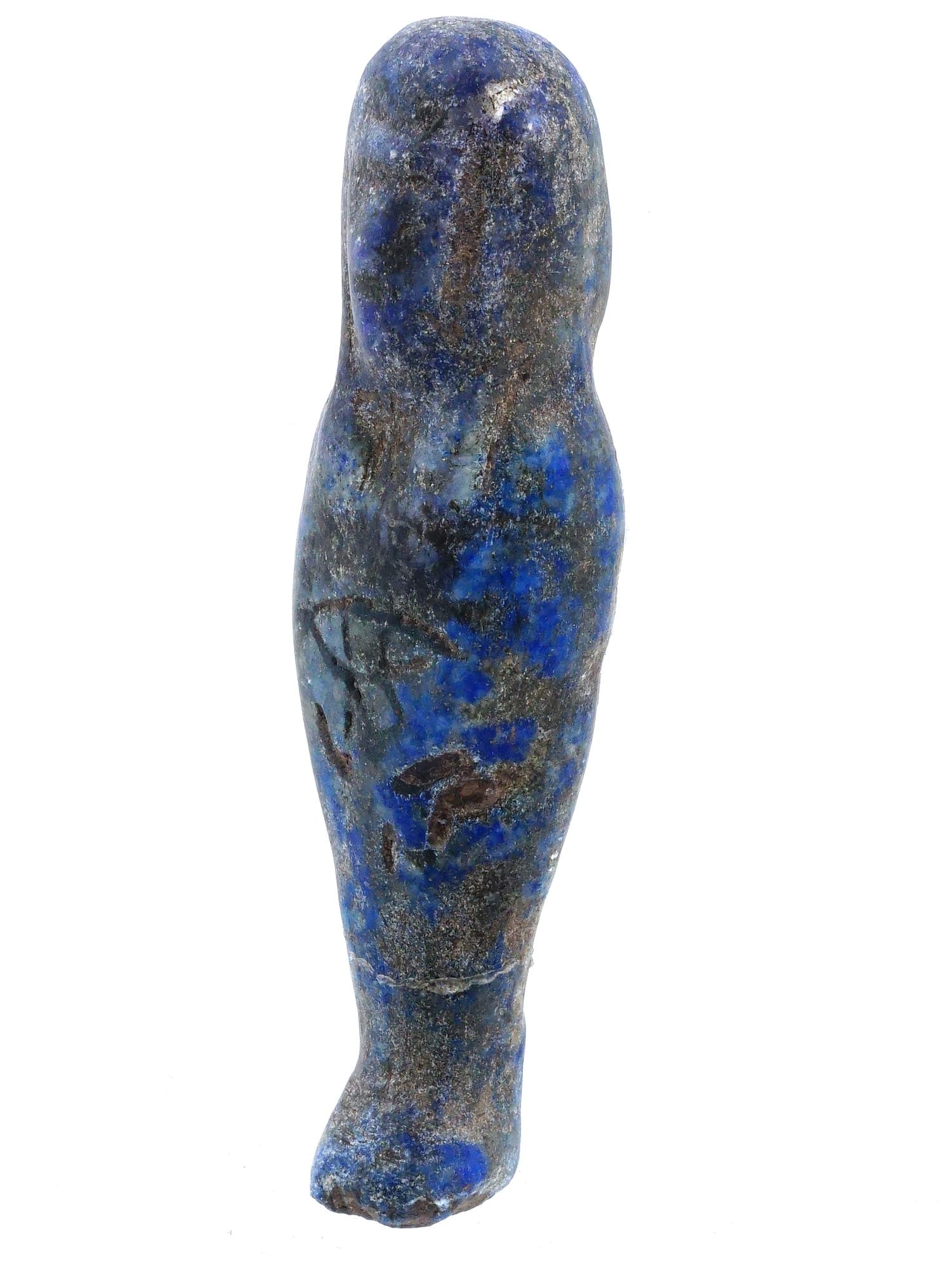 ANCIENT EGYPTIAN IDOL HAND CARVED OF LAPIS LAZULI: An ancient Egyptian idol hand carved of lapis lazuli. The idol is shaped like a standing figure, likely representing a deity or an important person. It features an engraved image of the eye on the fro