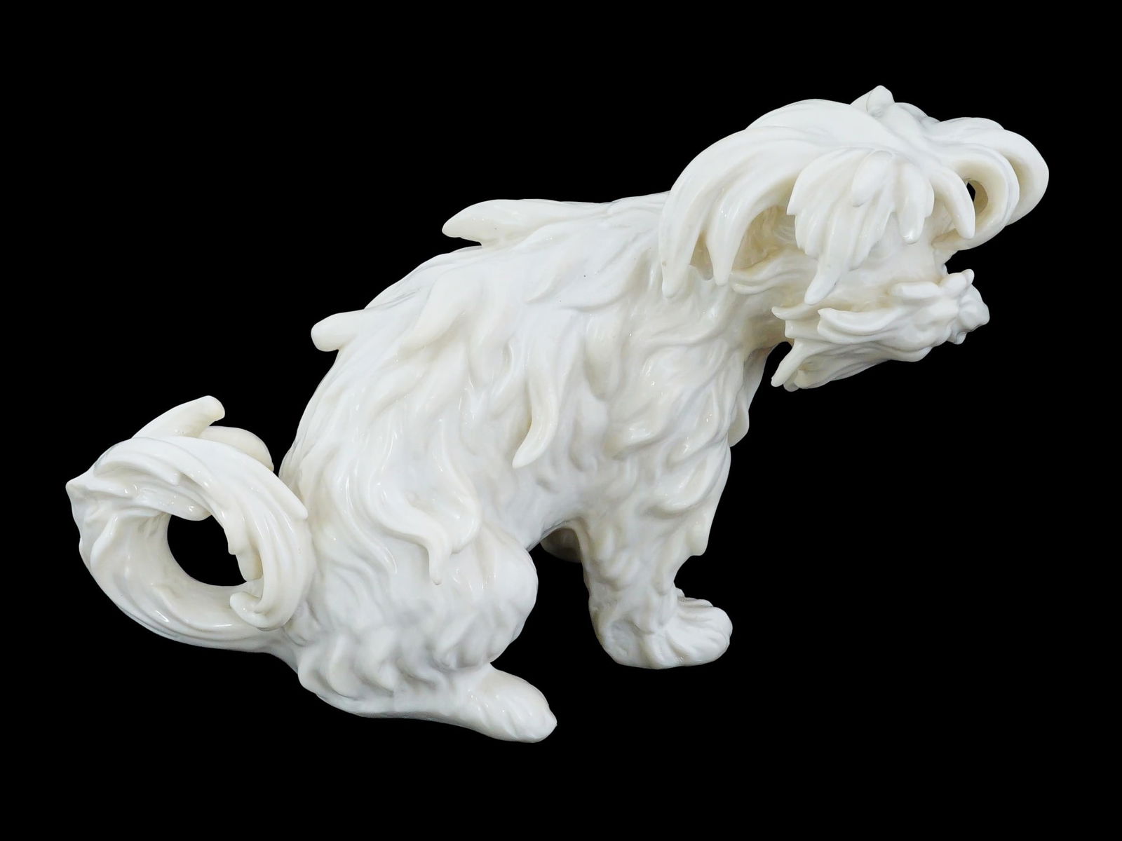 LARGE ANTIQUE GERMAN PORCELAIN LAP DOG FIGURE: A large antique German school porcelain lap dog figure. Presumably made by Meissen. The fine, well detailed dog figure represents a seated fluffy shaggy lap dog with a curled tail. Antique And Vintage