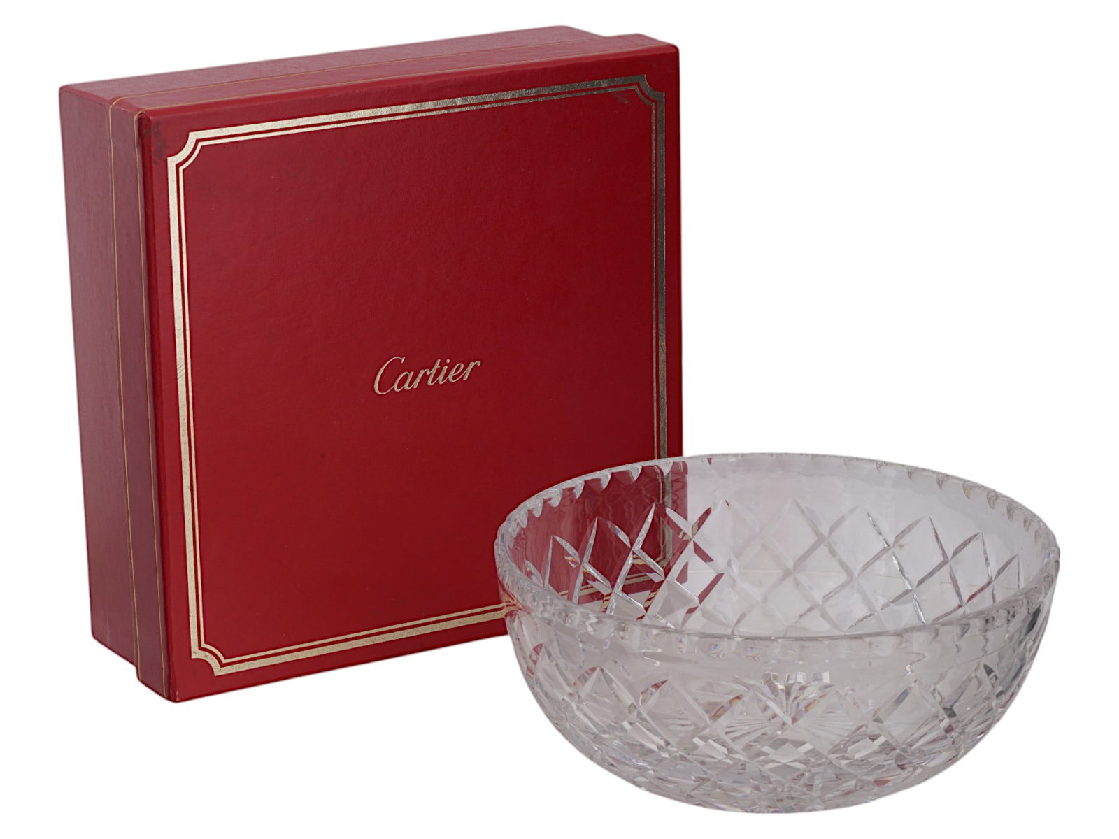 VINTAGE CARTIER CUT GLASS SERVING BOWL IOB: A vintage cut leaded glass bowl by Cartier. Round piece with grid design. The item comes in original box with label tag dated 1987. Collectible Luxury Glassware, Tableware And Serveware. Dimensions: D