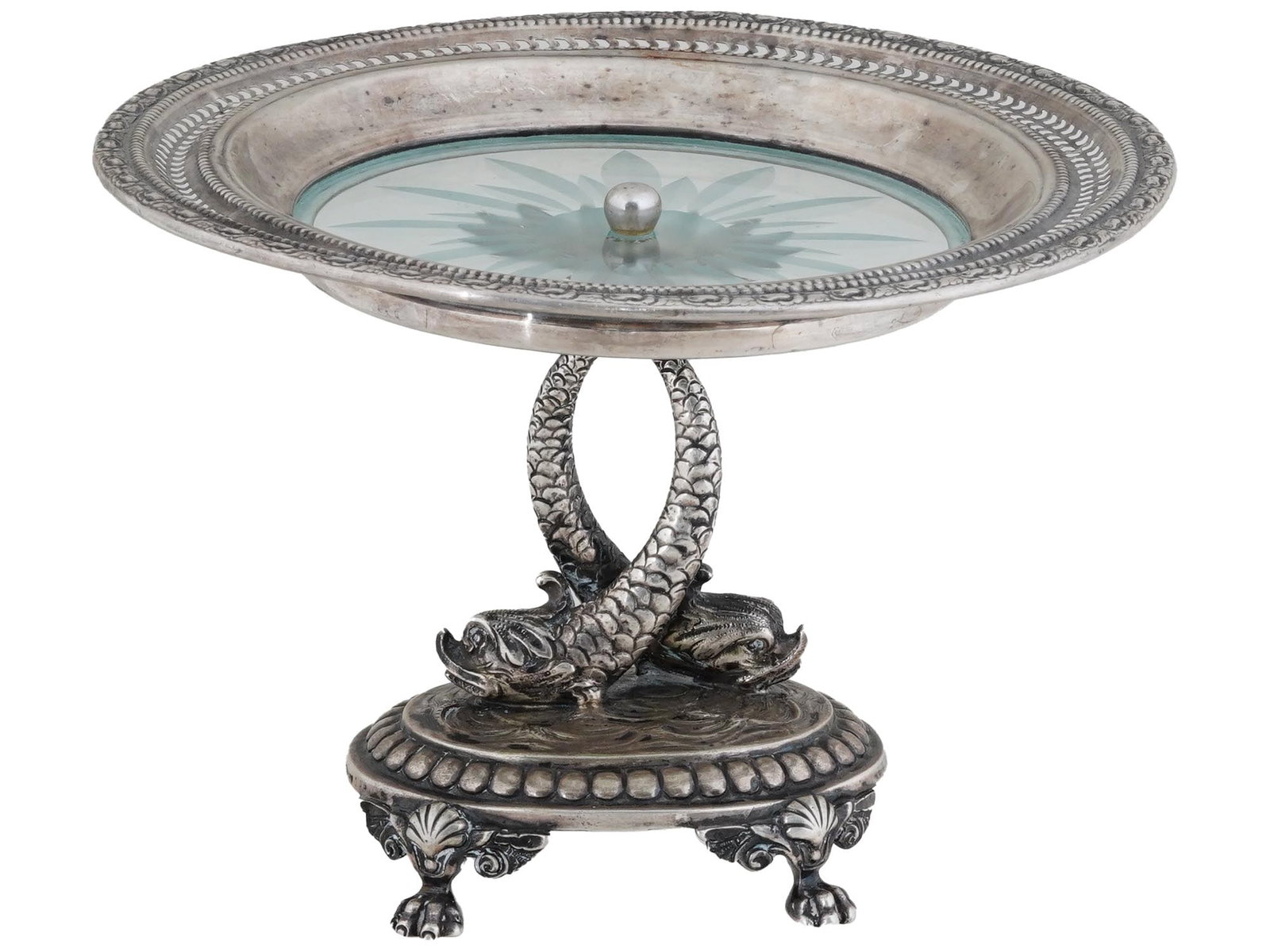 ANTIQUE SILVER CENTERPIECE ROUND SILVER AND CRYSTAL TOP: An antique silver centerpiece featuring a round top with a crystal base. The stem is modeled in the shape of two fishes with crossed tails. The base is adorned with decorative elements, and four feet 
