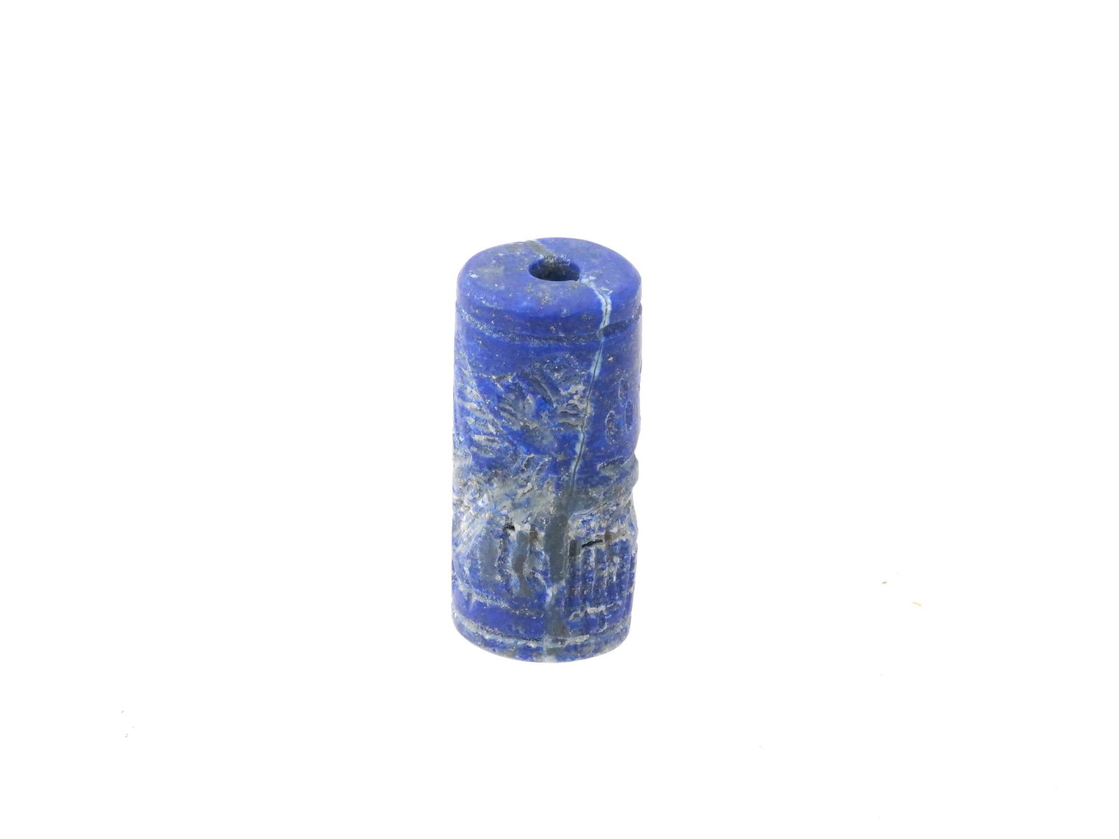 ANCIENT NEAR EASTERN CARVED HARDSTONE CYLINDER SEAL: An ancient Near Eastern cylinder shaped hand carved hardstone, probably Lapis Lazuli, bead seal. The imprint depicts zoomorphic figures and traditional ornaments. This seal, meticulously carved with i