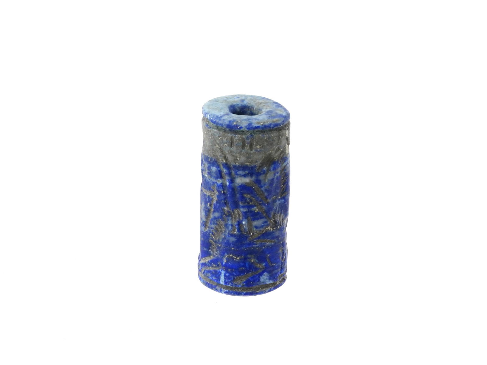 ANCIENT NEAR EASTERN CARVED HARD STONE CYLINDER SEAL: An ancient Near Eastern cylinder shaped hand carved hardstone, probably Lapis Lazuli, bead seal. The imprint depicts zoomorphic figures and traditional ornaments. This seal, meticulously carved with i