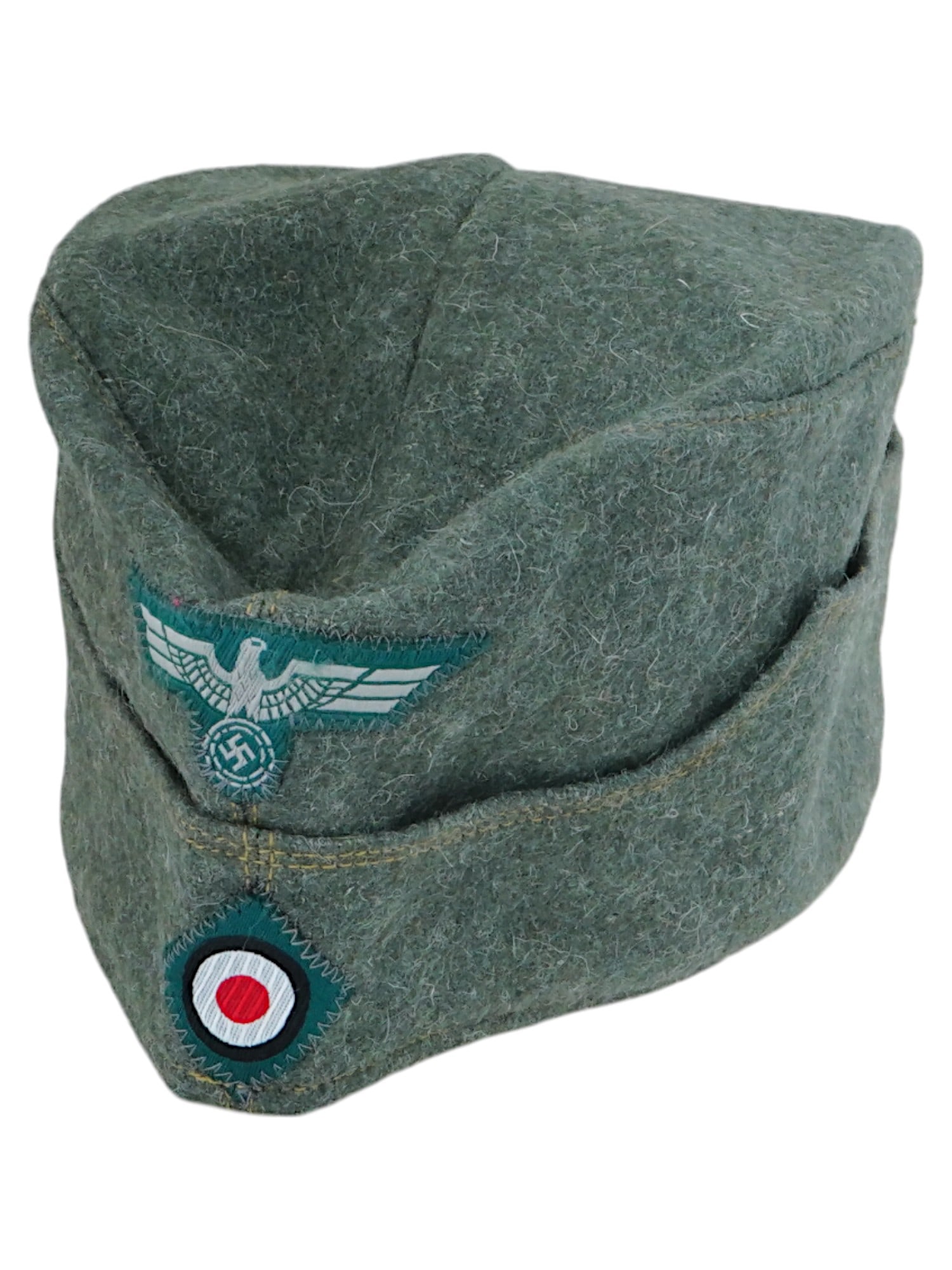 WWII NAZI GERMAN WEHRMACHT INFANTRY OVERSEAS CAP: A World War II German EM SS overseas cap of Wehrmacht Infantry. Green wool narrow hat that could be folded flat and tucked into a belt or haversack. The front bears a complete set of insignia with Rei