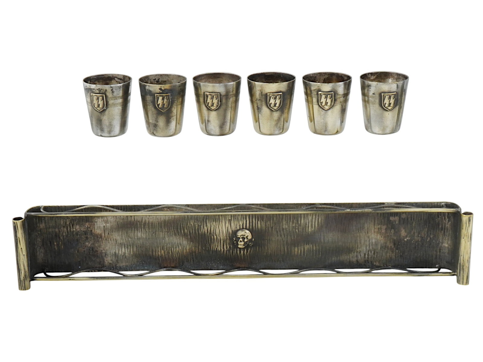 WWII NAZI GERMAN WAFFEN SS SCHNAPPS SHOT CUPS AND TRAY: A set of six WWII Nazi German Waffen SS schnapps shot cups and a tray, comprising seven items in total, though one cup is missing. Each of the shots is decorated with the distinctive SS runes, which w