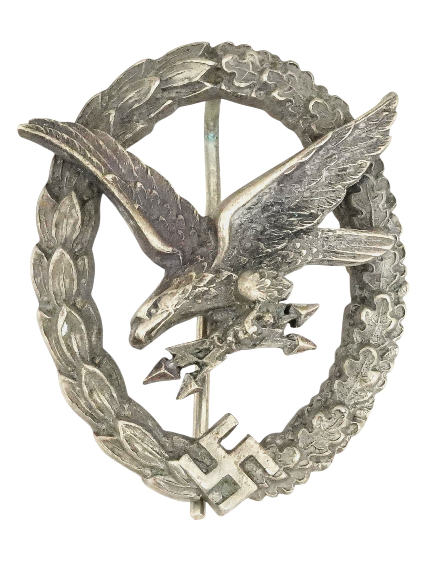 WWII GERMAN LUFTWAFFE RADIO OPERATOR AIR GUNNER BADGE: A WWII German Luftwaffe Radio Operator and air gunner badge. The badge is an oval wreath of laurel and oak leaves with a flying eagle in the center holding lightning bolts in its talons. The German sw