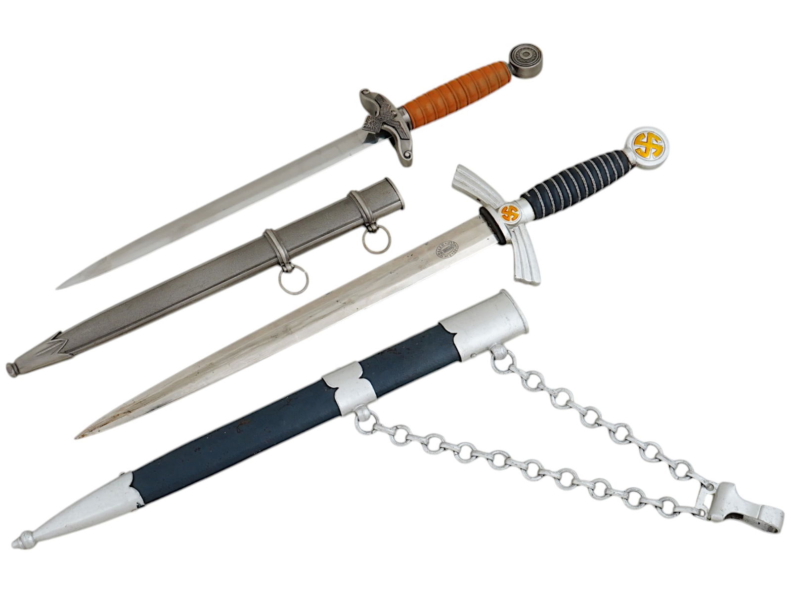 WWII NAZI GERMAN 1ST MODEL LUFTWAFFE AND TENO DAGGERS: A WWII Nazi German 1st Model Luftwaffe officers dagger, featuring a double-edged blade. The pommel and crossguard showcase a brass-colored rotating broken sun cross, while the grip is covered in dark