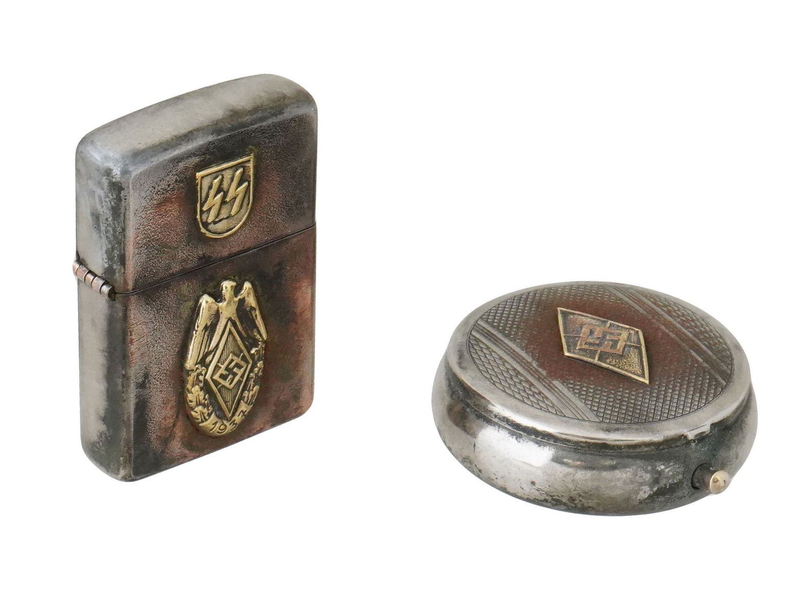 WWII NAZI GERMAN WAFFEN SS HITLERJUGEND ASTRAY LIGHTER: A group of two WWII Nazi German Waffen SS division Hitlerjugend items, including a pocket ashtray and a cigarette lighter. Both pieces prominently feature the Hitlerjugend insignia, symbolizing the pa