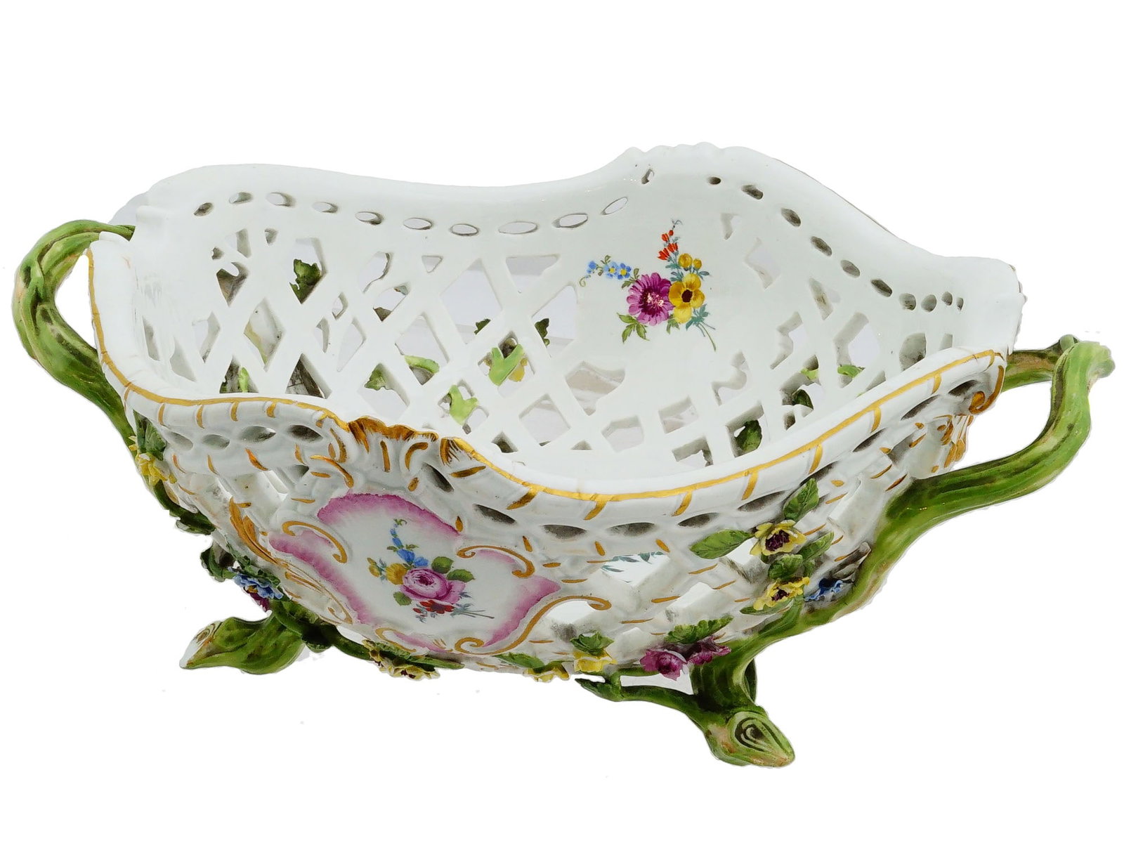 ANTIQUE MEISSEN RETICULATED PORCELAIN CENTERPIECE: An antique German Meissen porcelain centerpiece or fruit bowl. The ware is adorned with a reticulated design. The bowl features delicately crafted handles and is finished with gilt accents. The base o