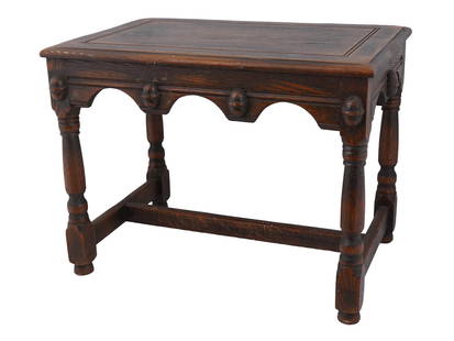 ANTIQUE ENGLISH OAK WOOD SIDE TABLE CA 19TH C: An antique English oak wood side table. Circa mid to late 19th century. The classic carved oak wood side table on four legs with a lower crossbar. The edge of the table under the tabletop is decorated